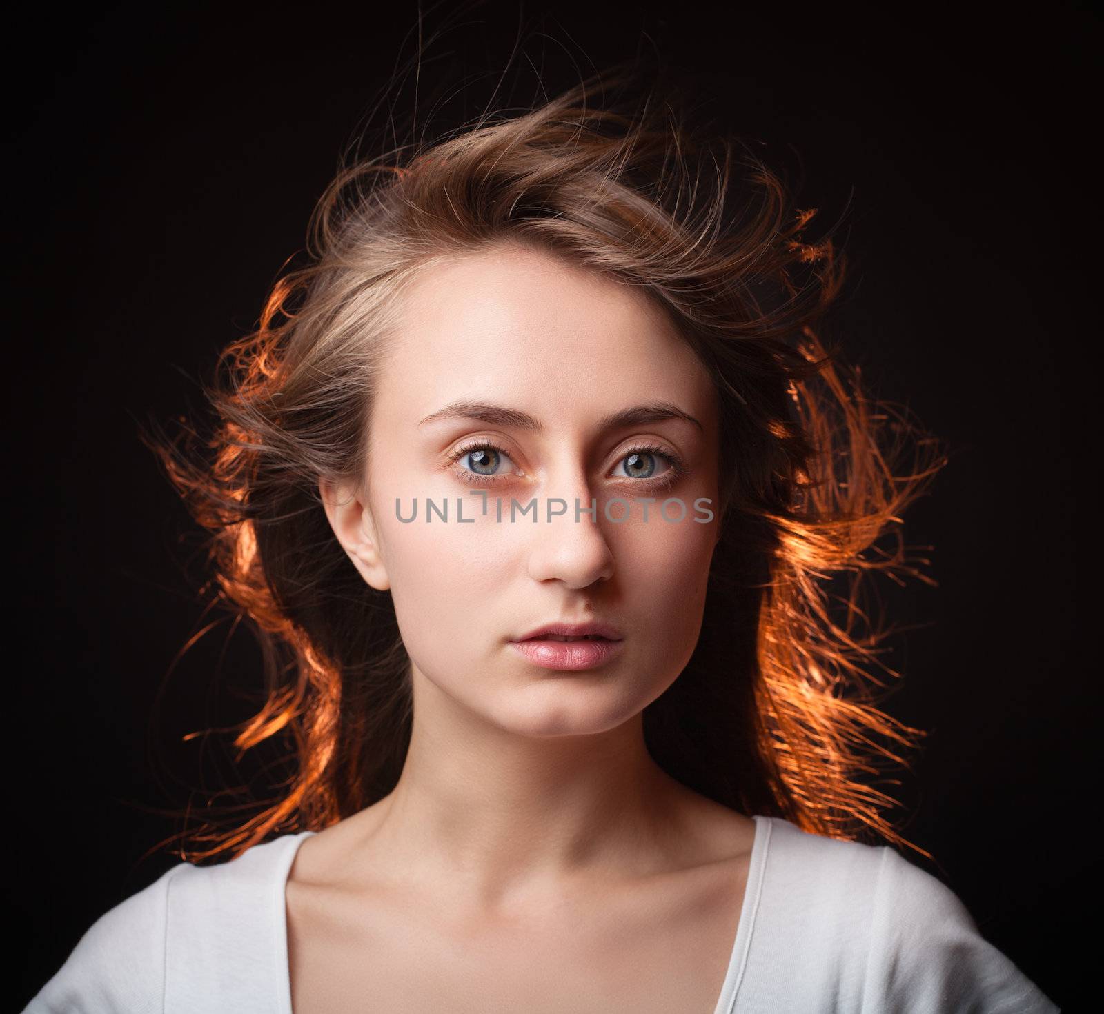 Portrait of a beautiful young woman on a dark background