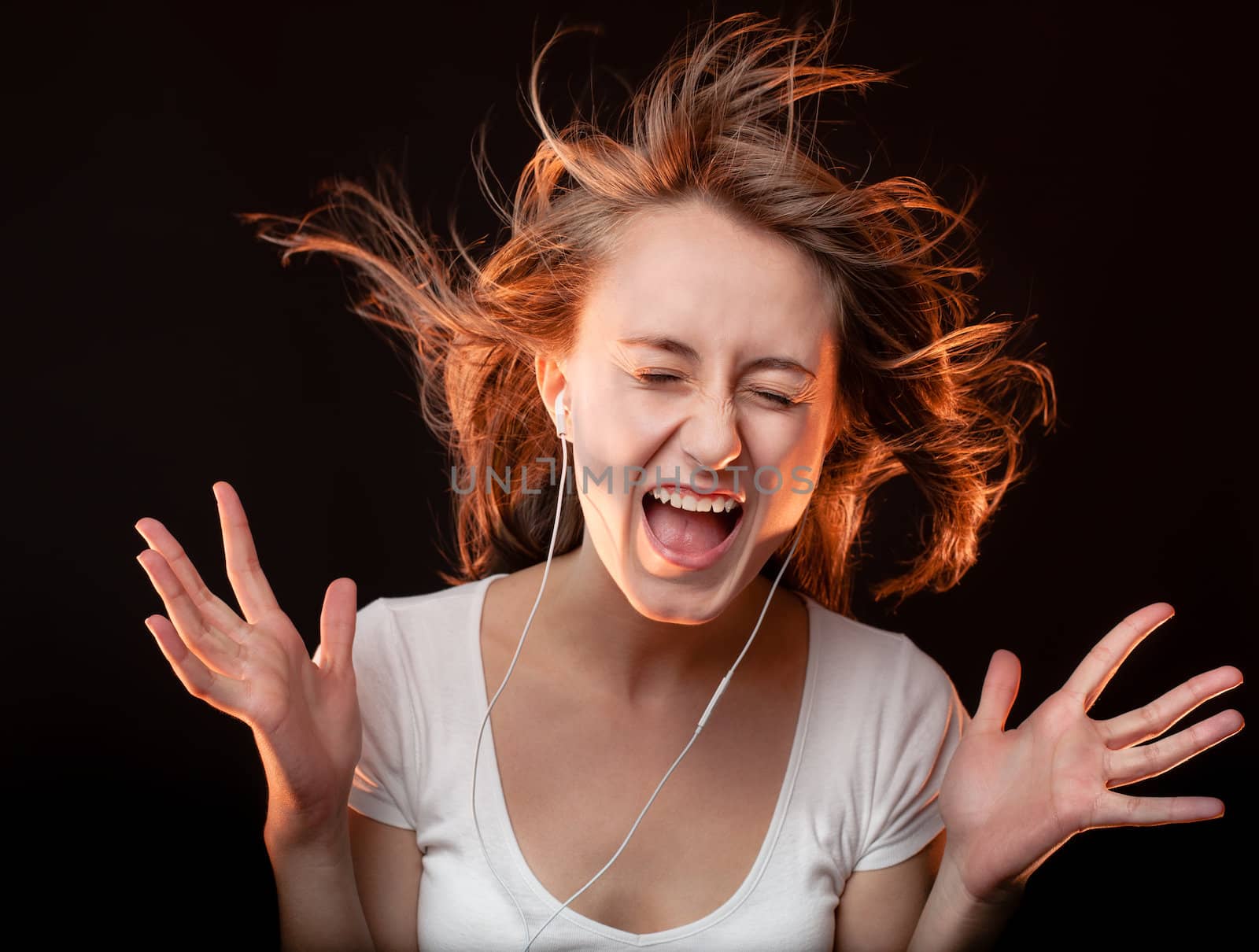 Beautiful Woman Listening Music and screams on a dark background