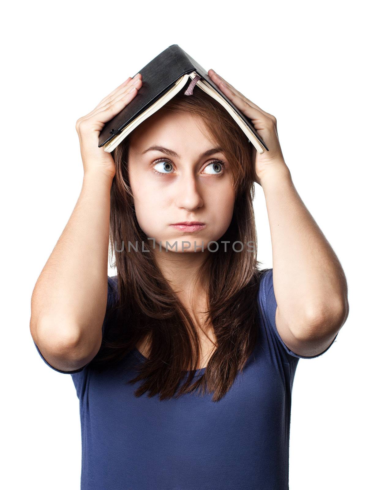 Education. Tired girl holds a notebook on her head on a white background