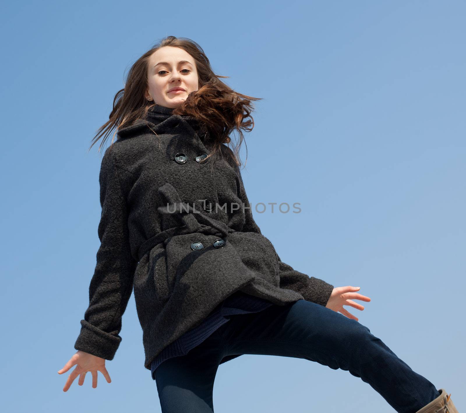 Joyful young woman against blue sky  background