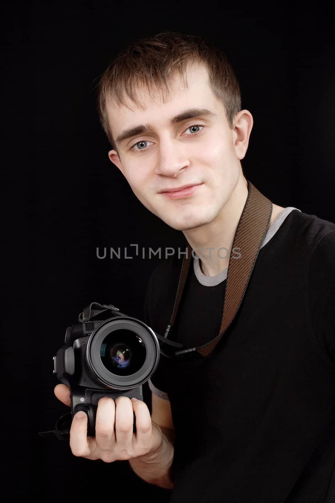 Young photographer at work isolated on black background