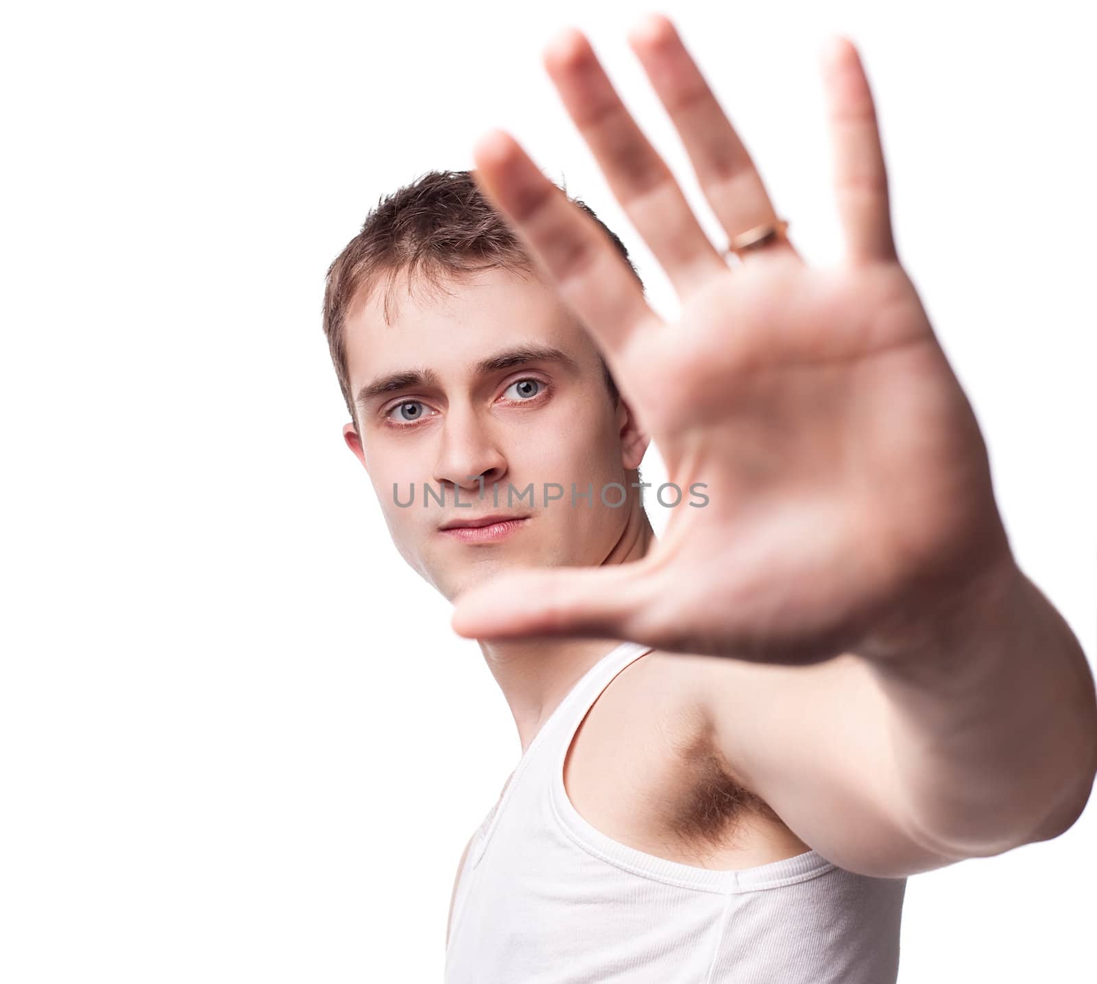 Portrait of a young man looking out from under raised hand on a white background