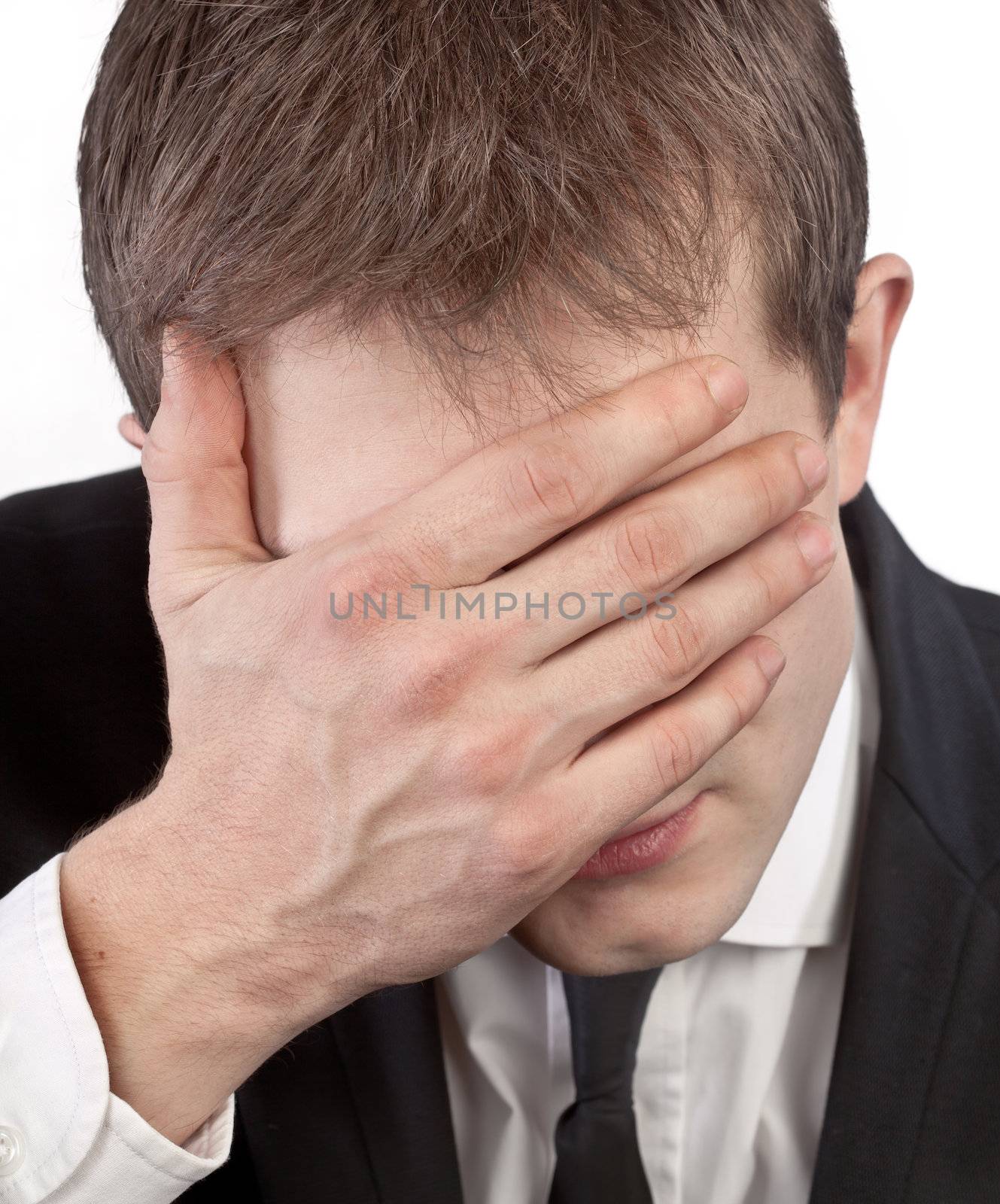 Depressed exhausted businessman covering his face by hand