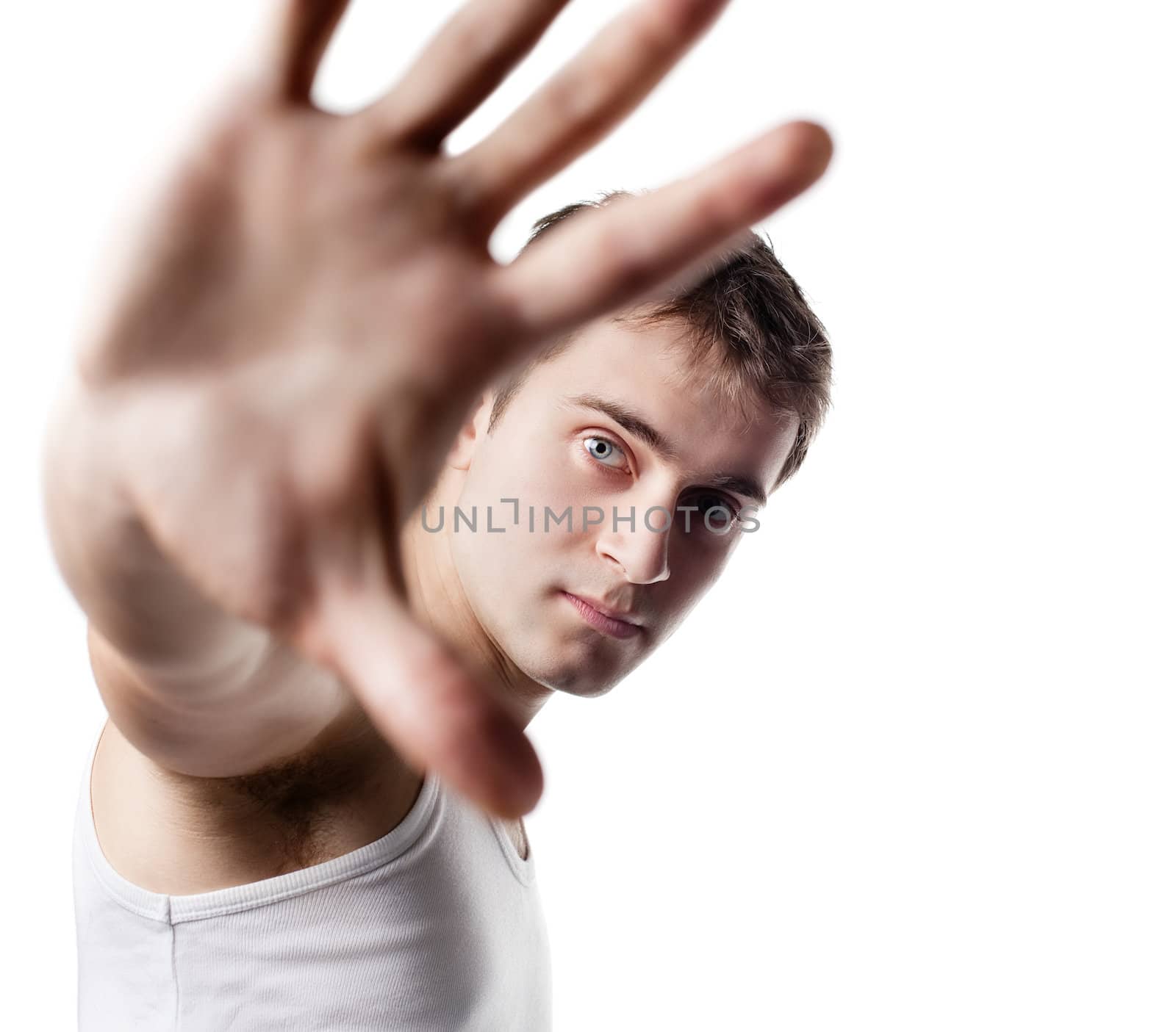 Portrait of a young man looking out from under raised hand on a light background