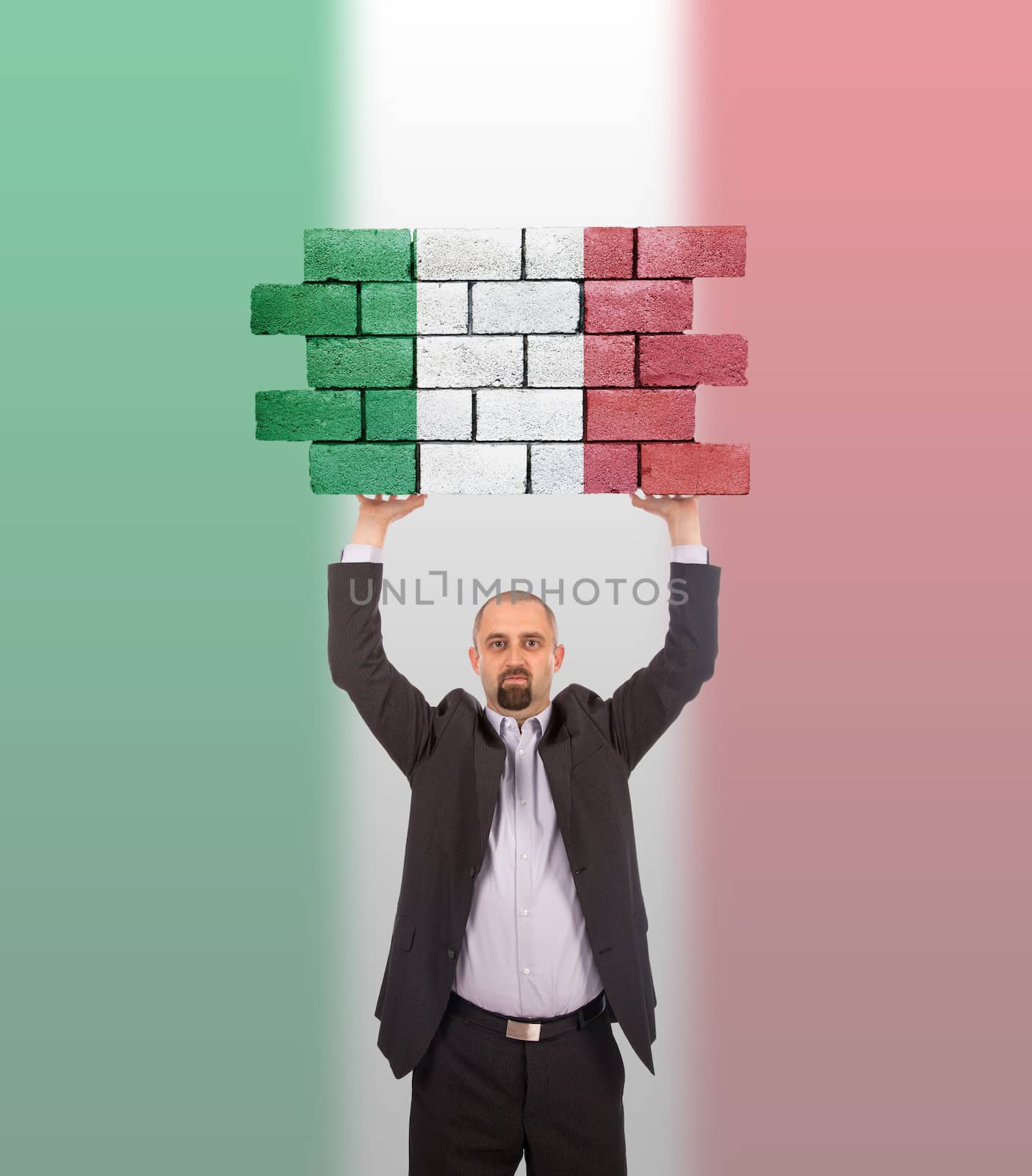 Businessman holding a large piece of a brick wall, flag of Italy, isolated on national flag