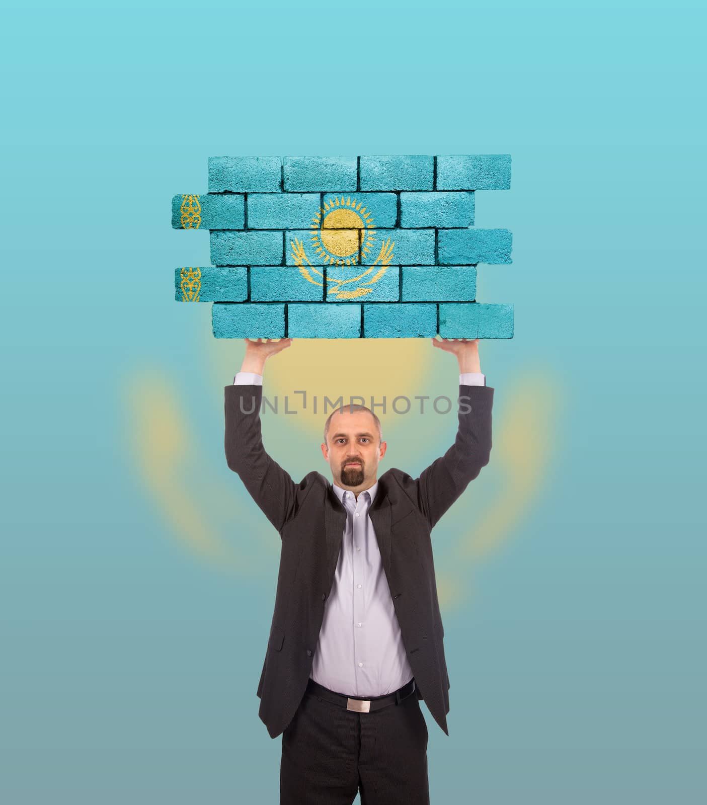 Businessman holding a large piece of a brick wall, flag of Kazakhstan, isolated on national flag