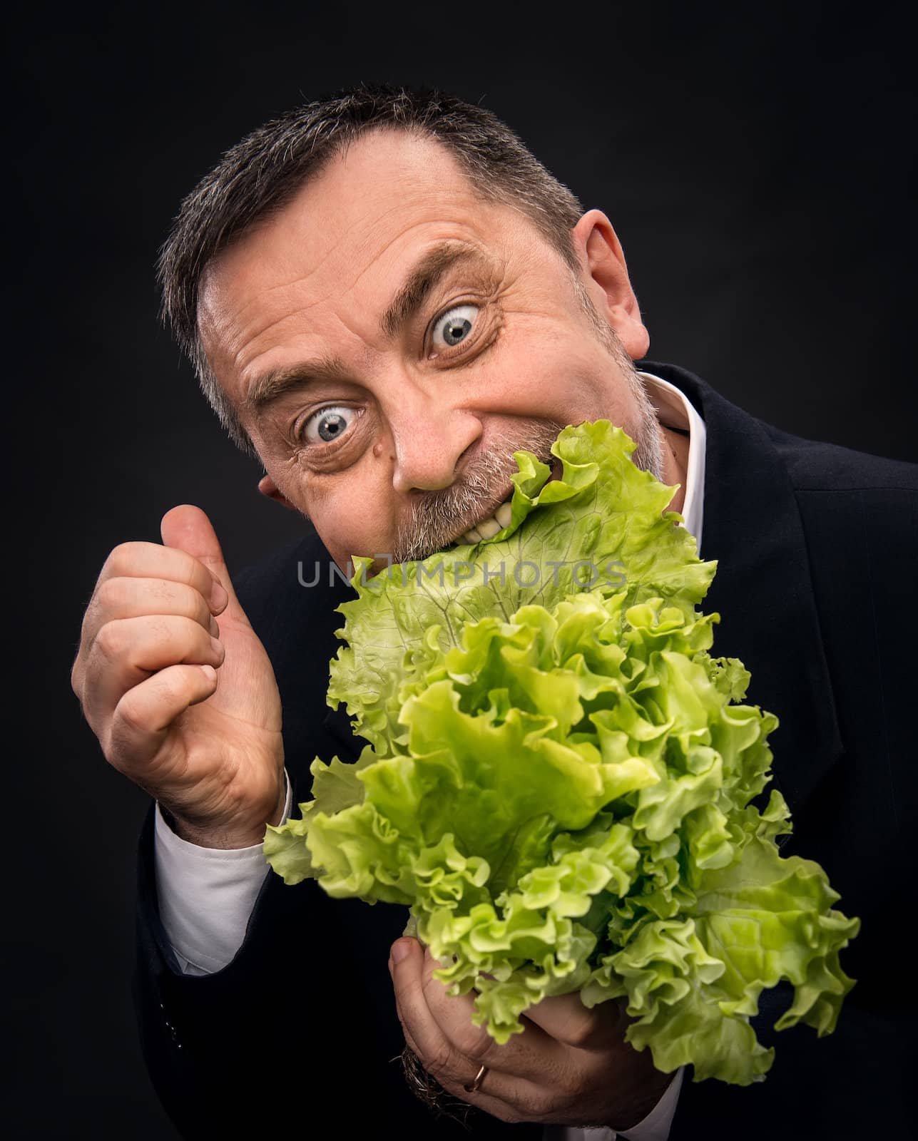 Healthy food. Man holding and eating lettuce