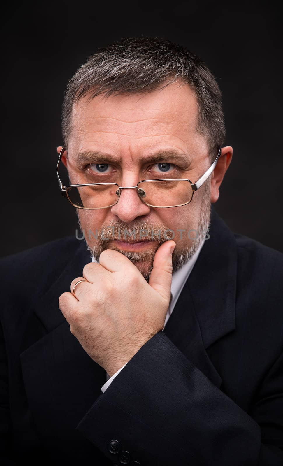 Portrait of handsome senior man with glasses prop up the head with his hand