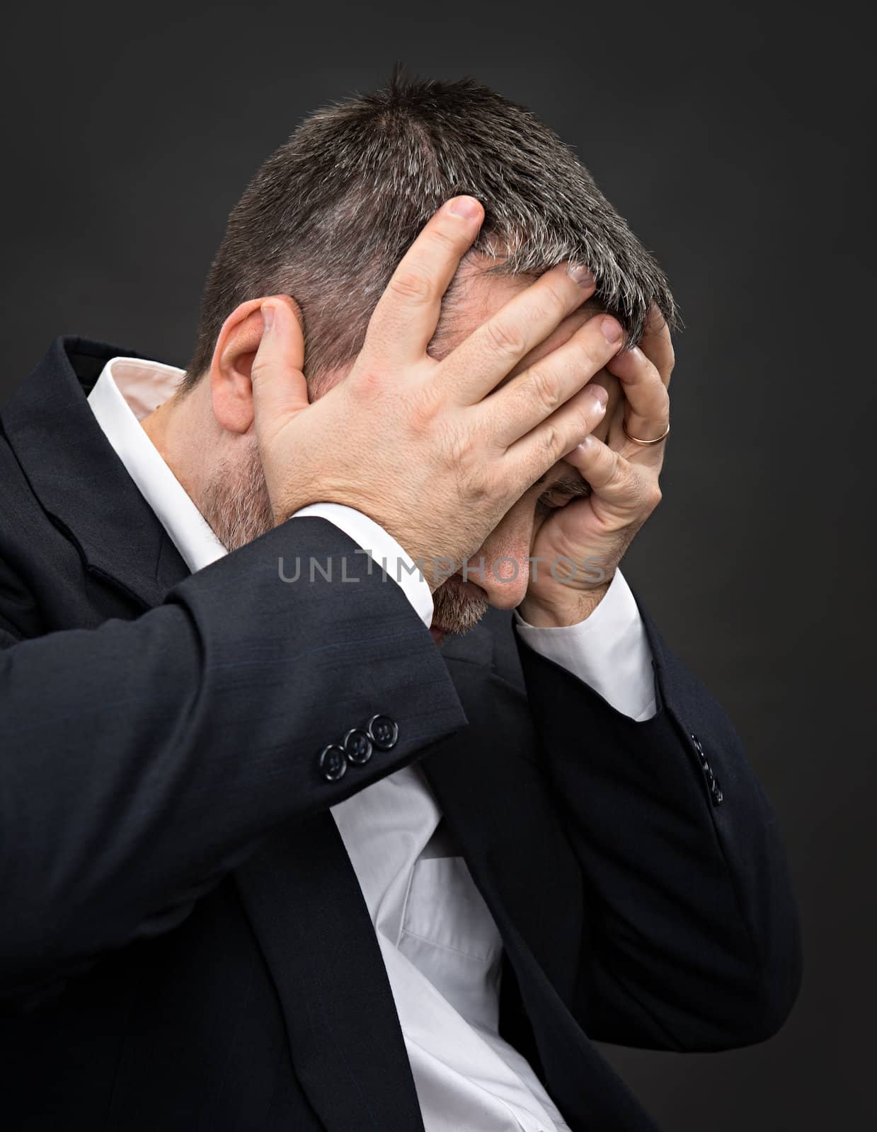 Headache. Portrait of an elderly man with face closed by hands