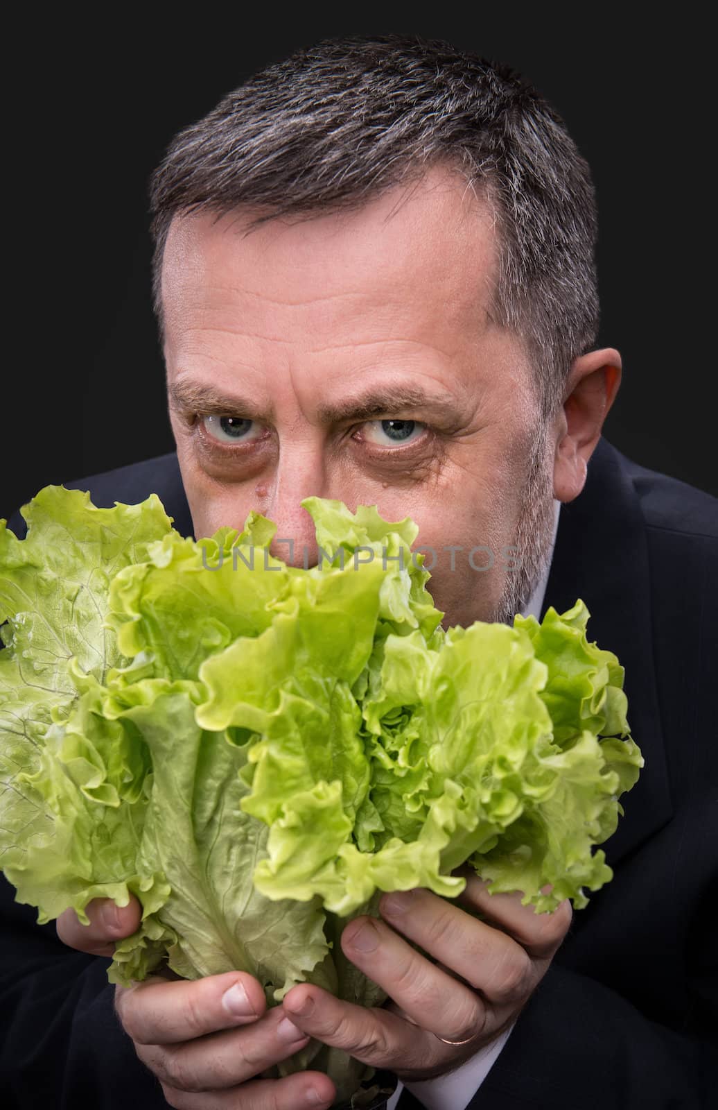 Healthy food. Man holding and eating lettuce