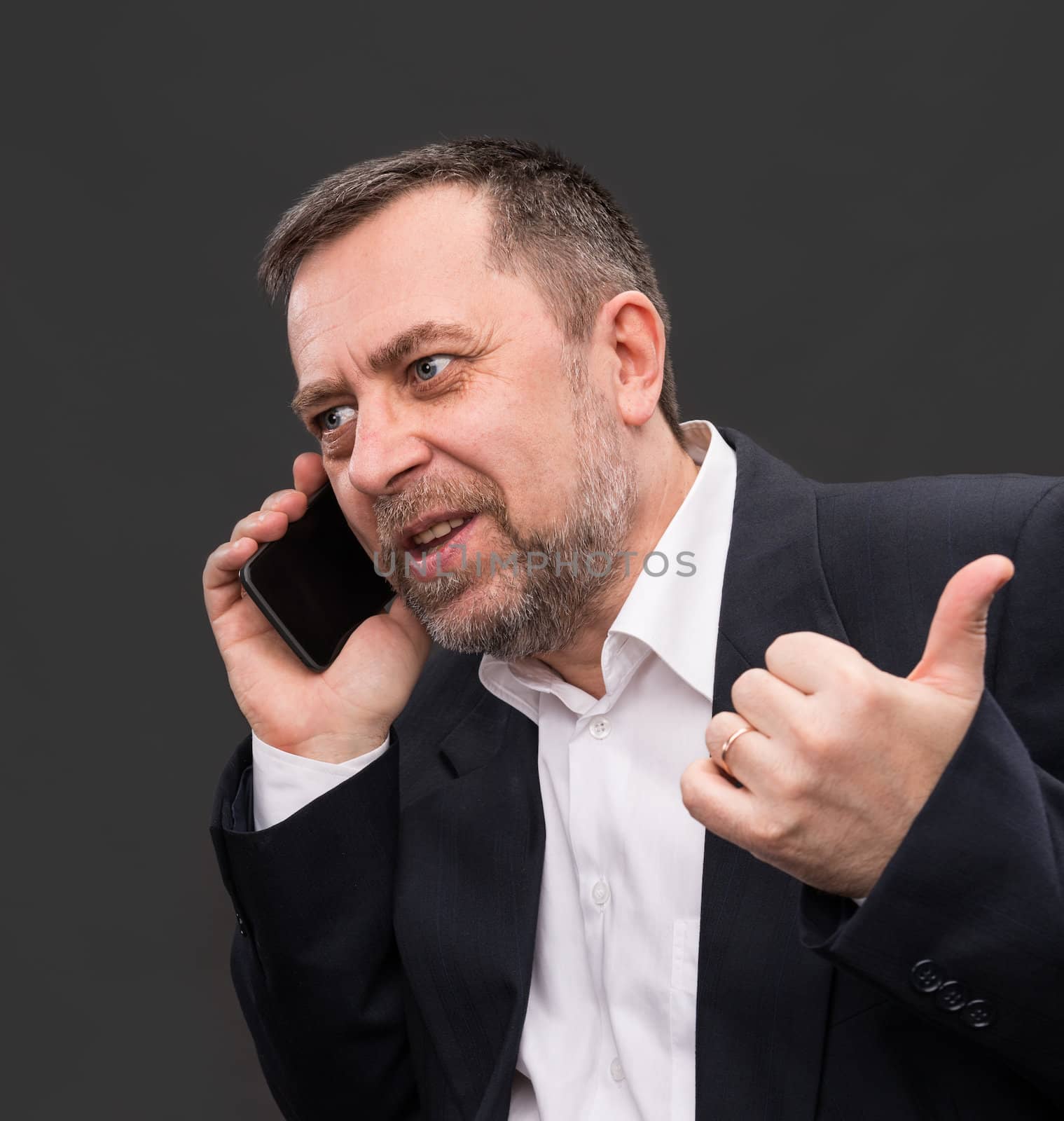 Handsome middle-aged business man speaks on a mobile phone and gesturing