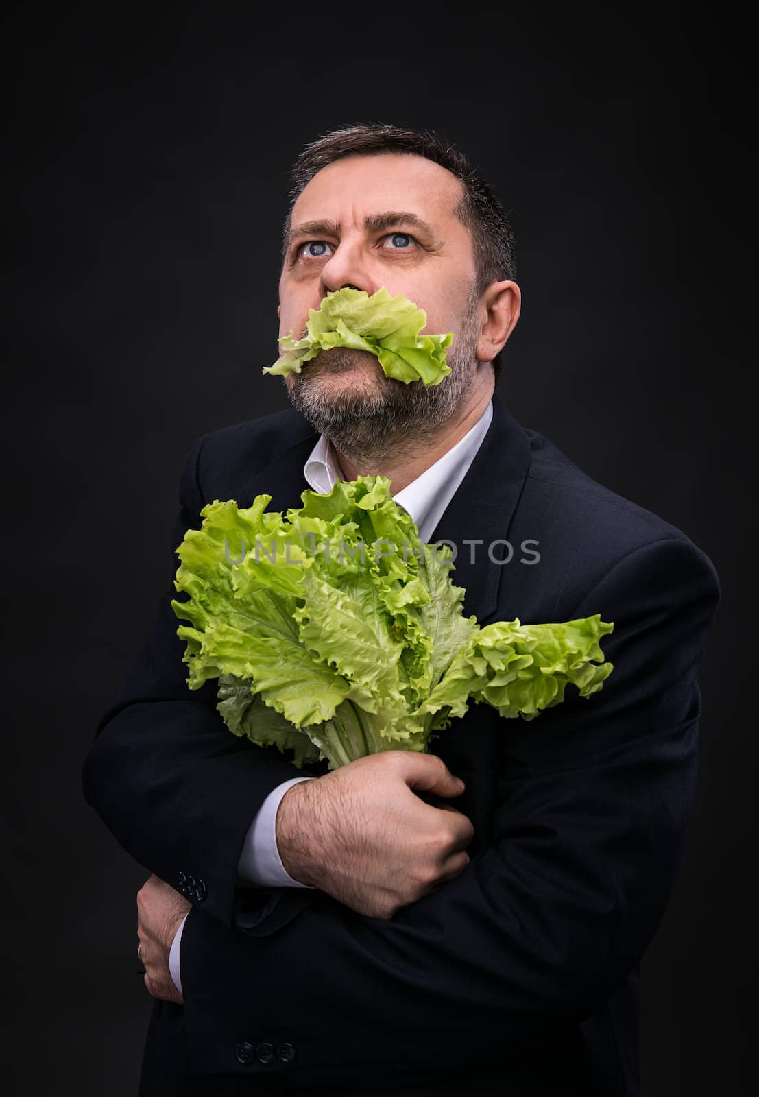 Healthy food. Man holding and eating lettuce