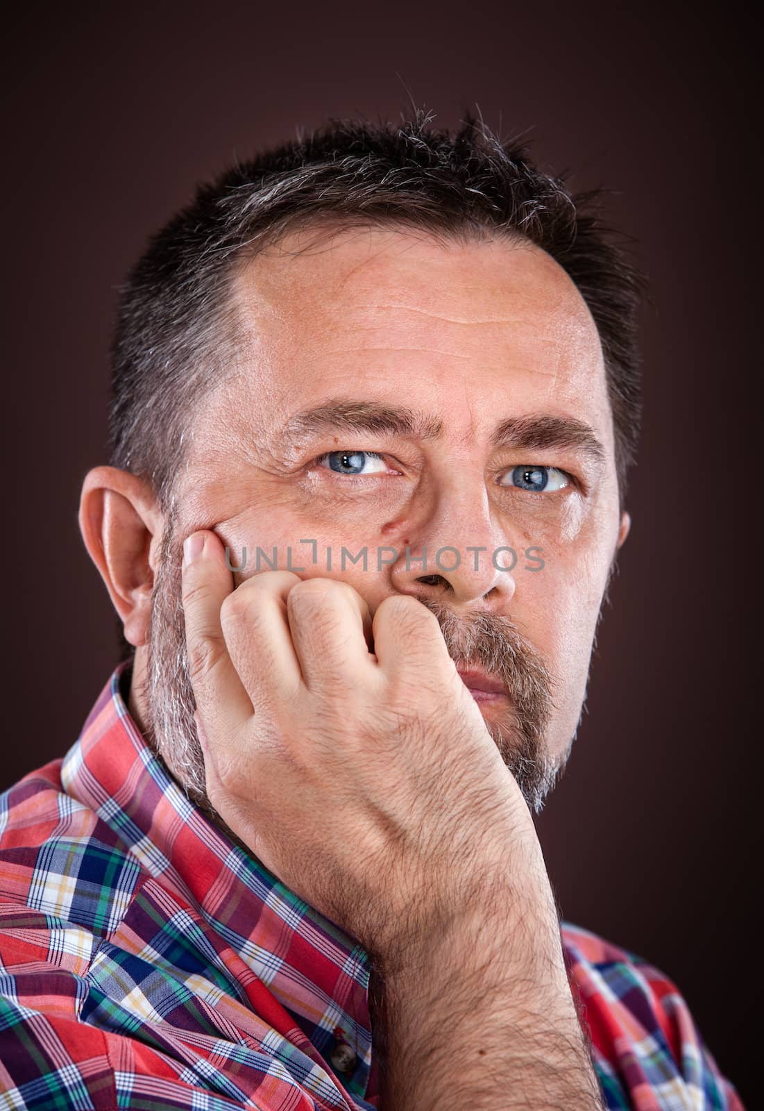 Portrait of a thoughtful elderly man with hand near the face
