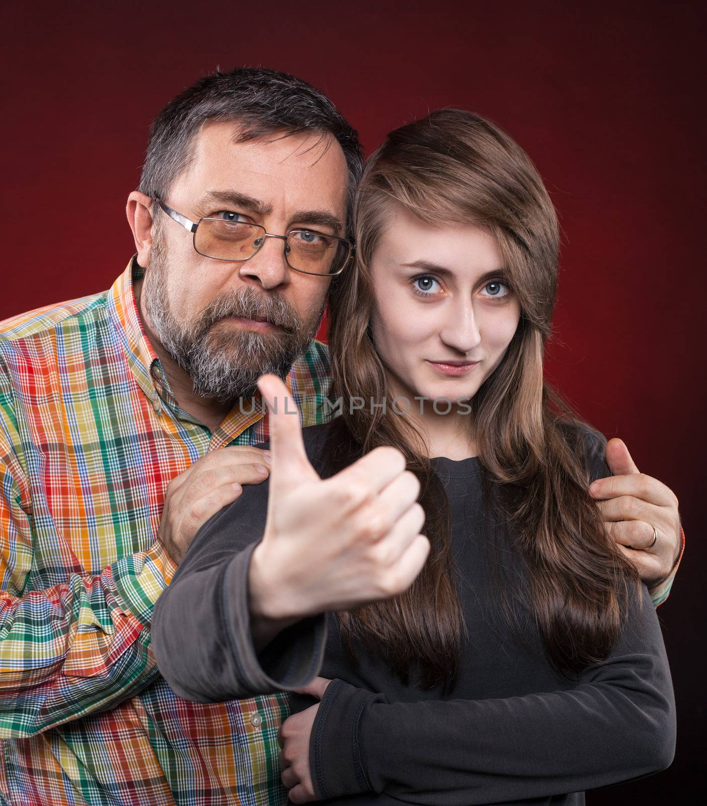Studio portrait of a father and daughter. Show OK symbol