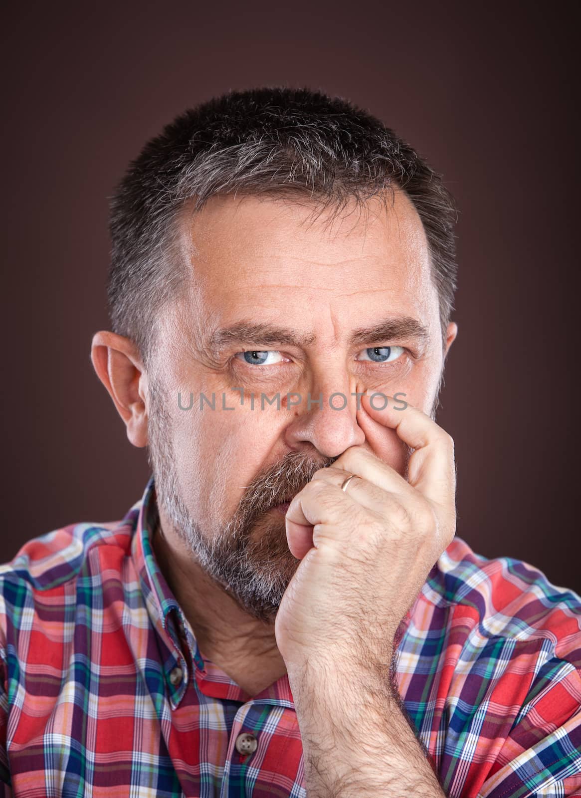 Portrait of a thoughtful elderly man with hand near the face