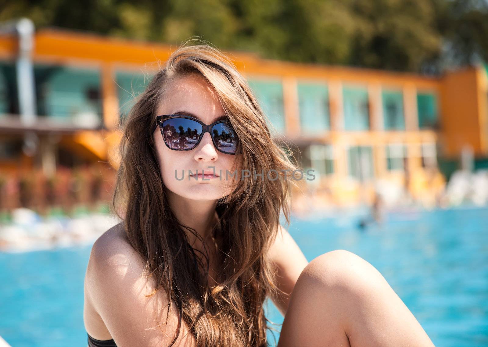 Young beautiful woman sunbathing near the pool