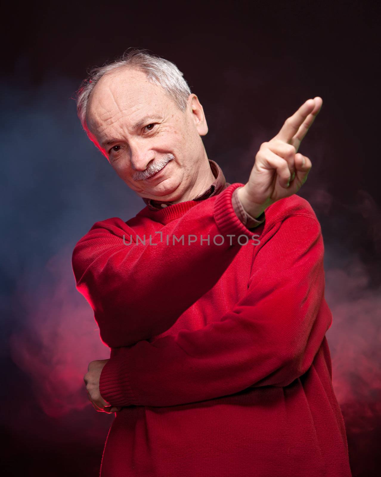 Successful old man in a red sweater gestures