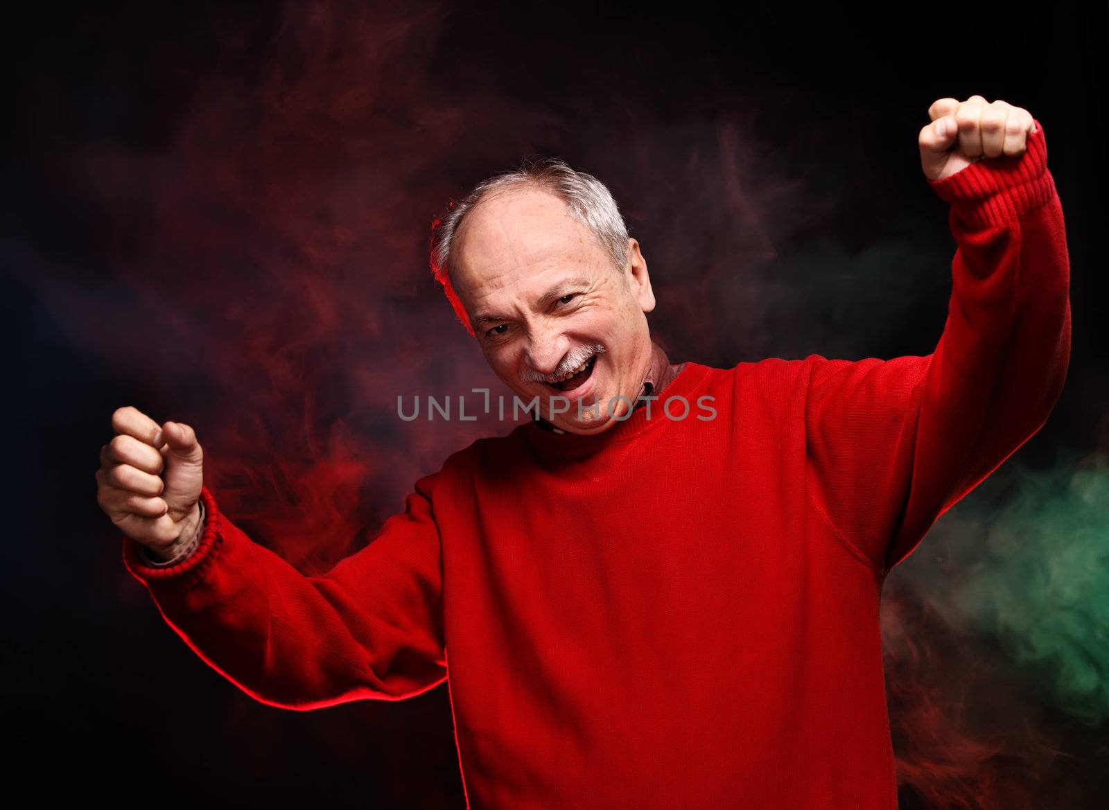 Successful old happy man in a red sweater gestures