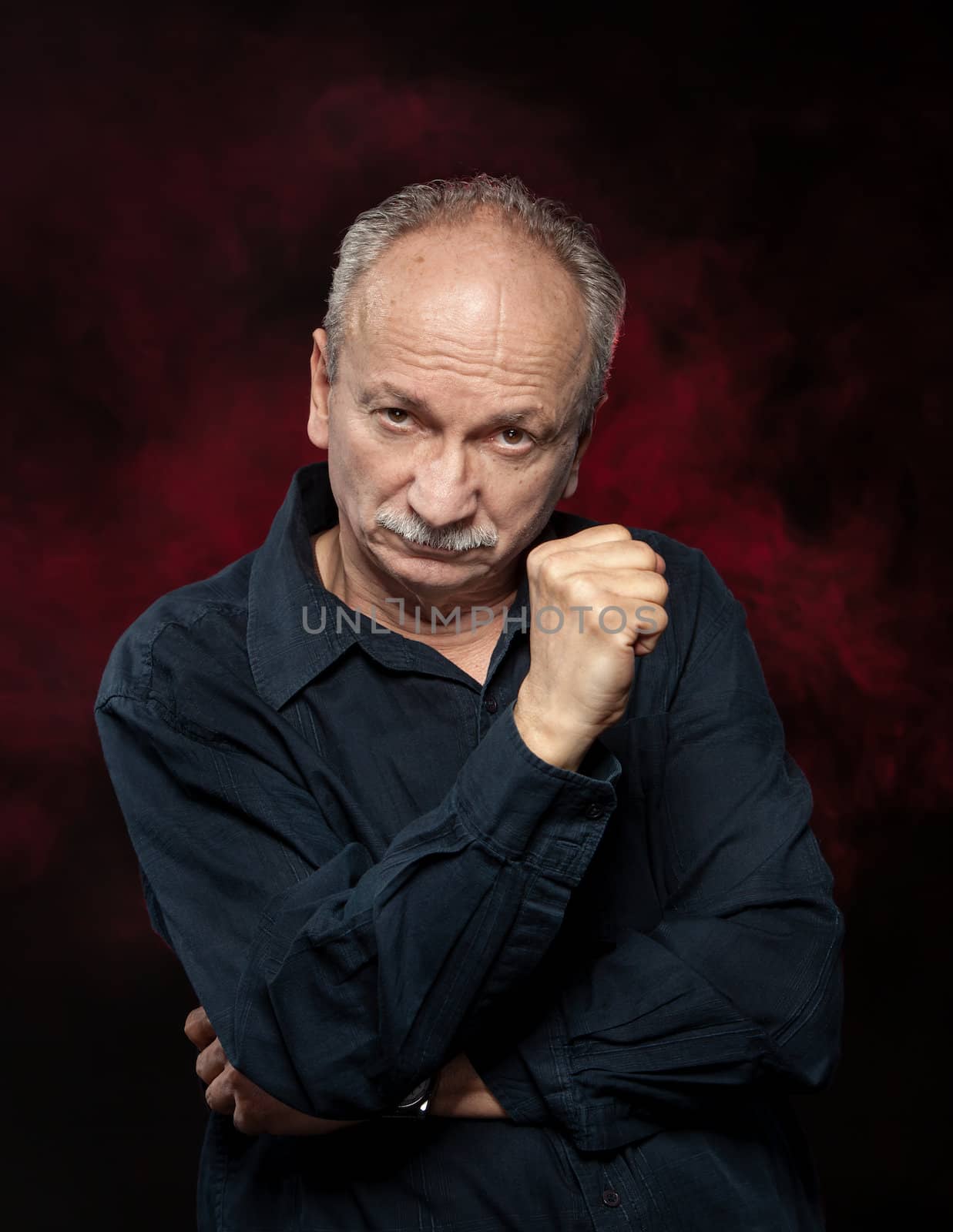 Handsome senior man in black shirt on dark background