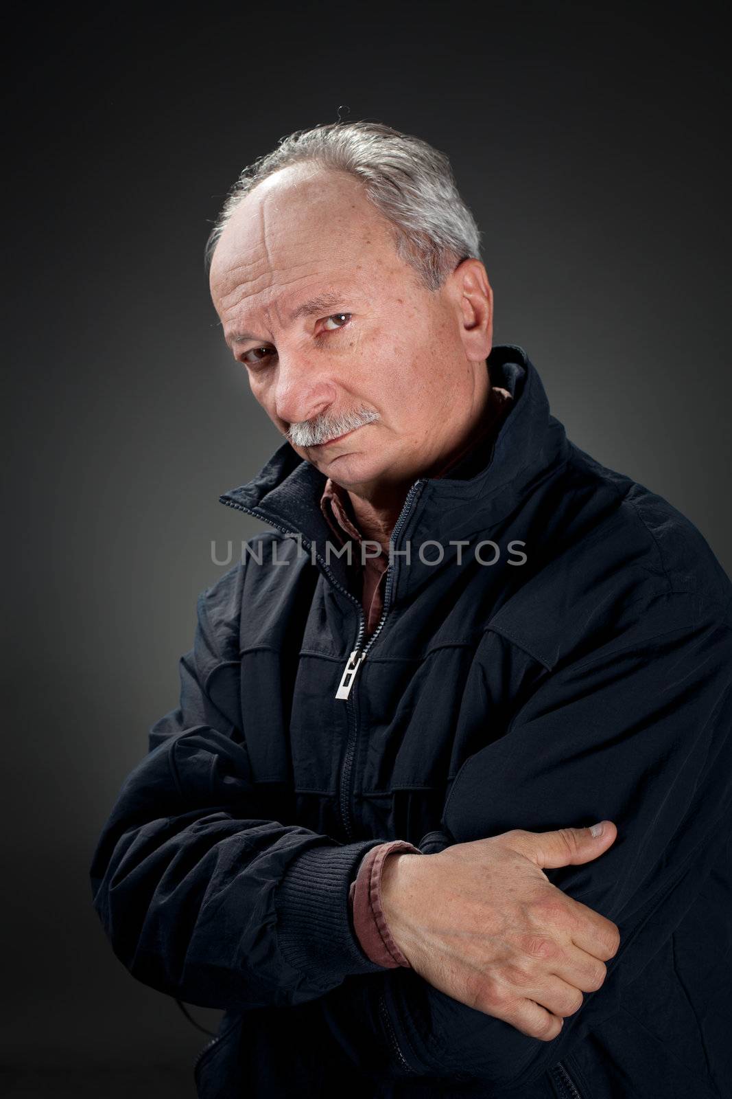 Portrait of a wise old man in a dark jacket