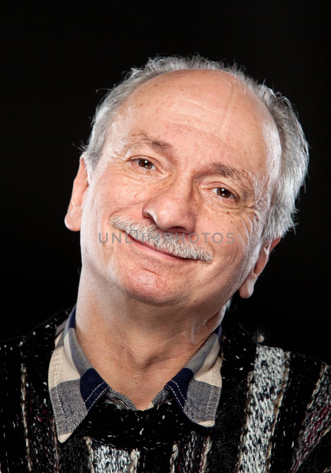 Portrait of happy senior man on black background