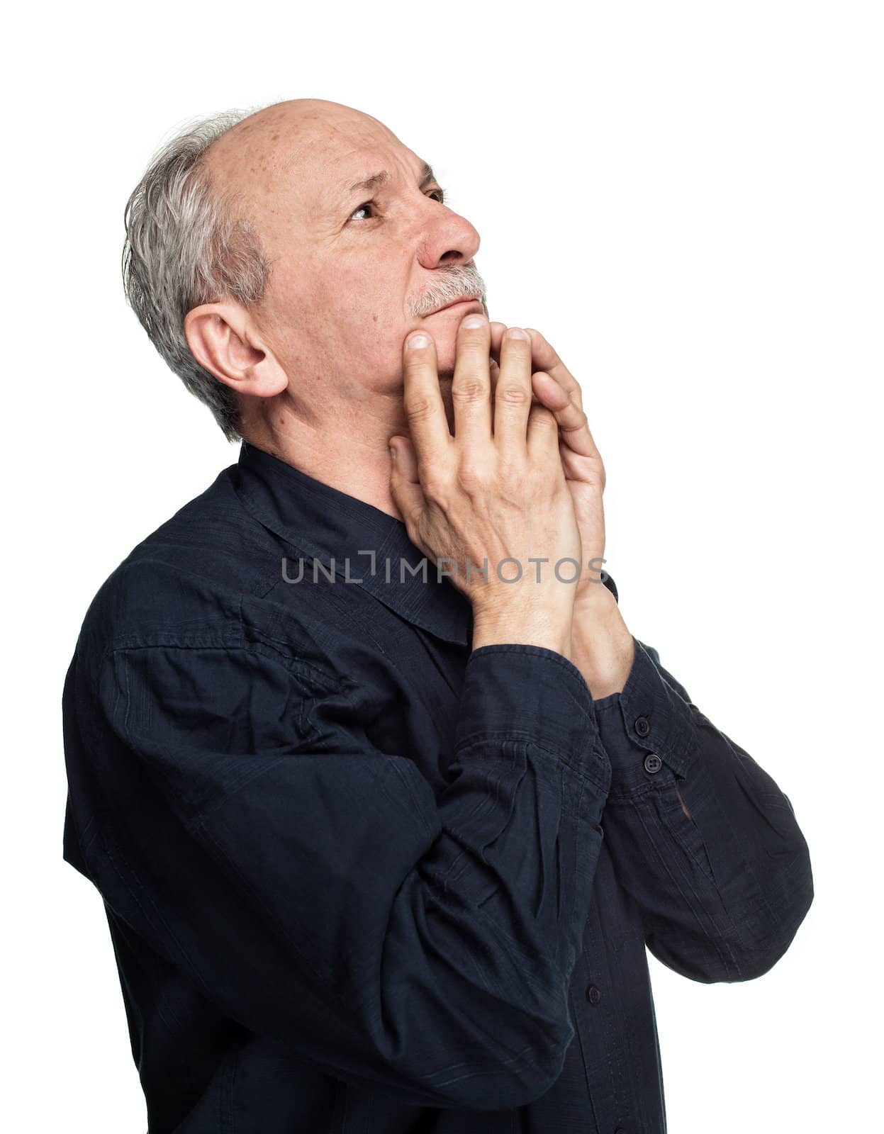 Elderly man with hands near his face  looking up thinking