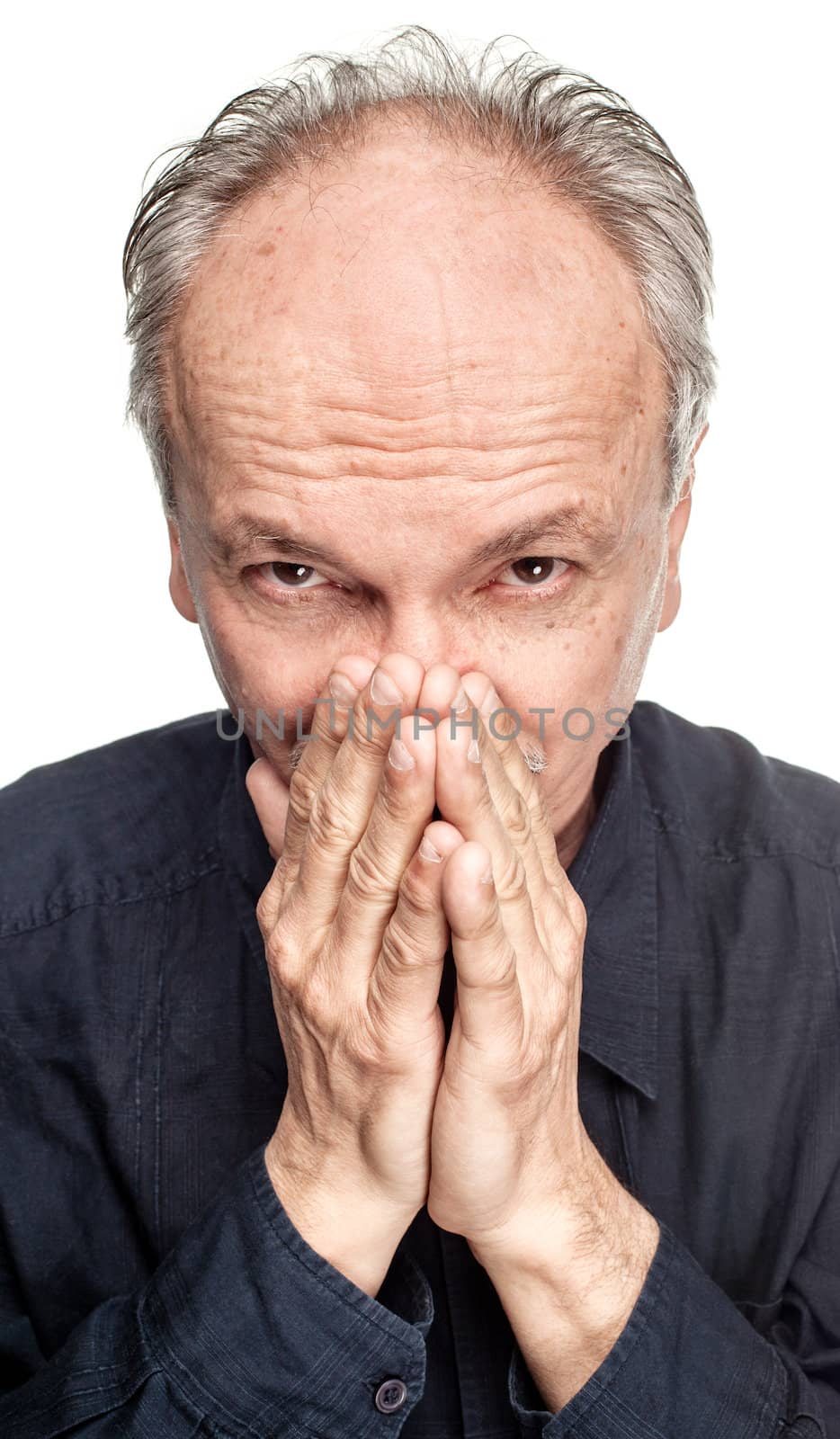 Elderly man covers his face with hand