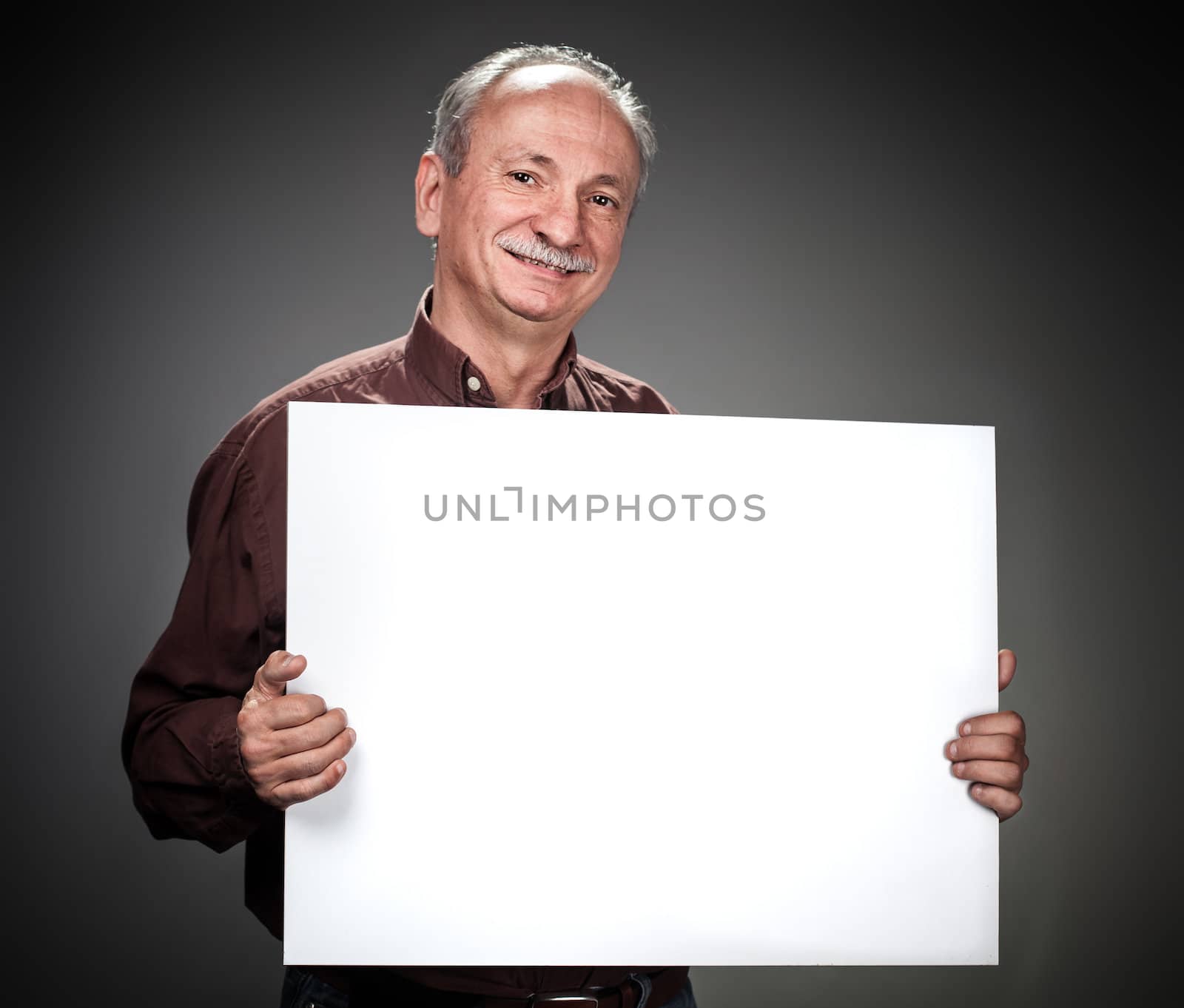 An elderly man holding a blank billboard