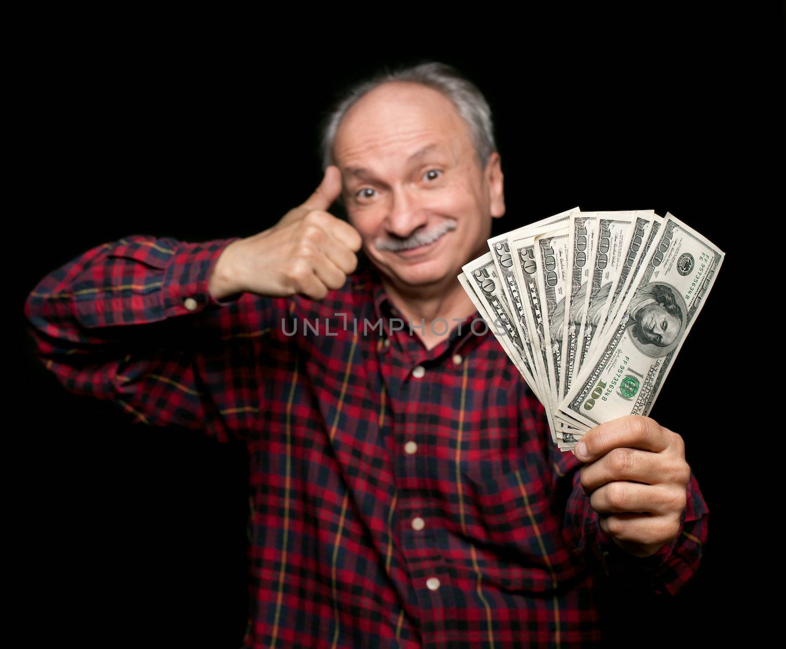 Happy elderly man showing fan of money and sign OK with fingers