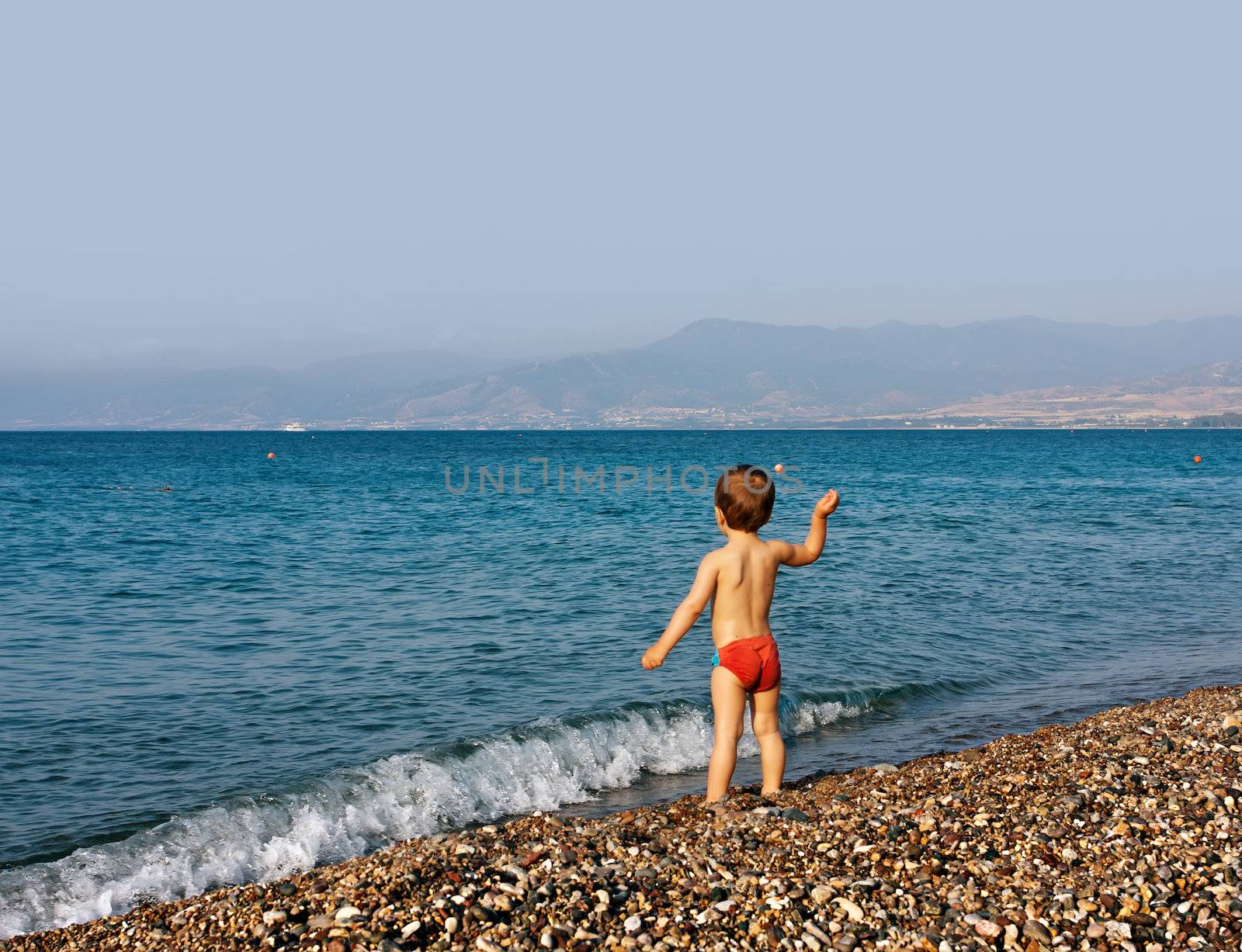 Boy playing on sea beach by palinchak