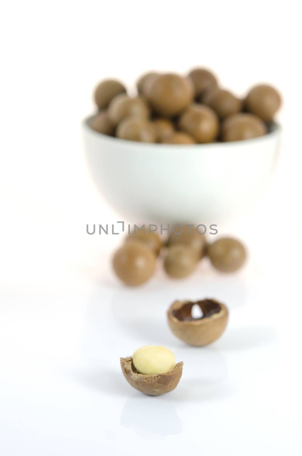 close up shelled  macadamia  and un shelled macadamia in cup on white background