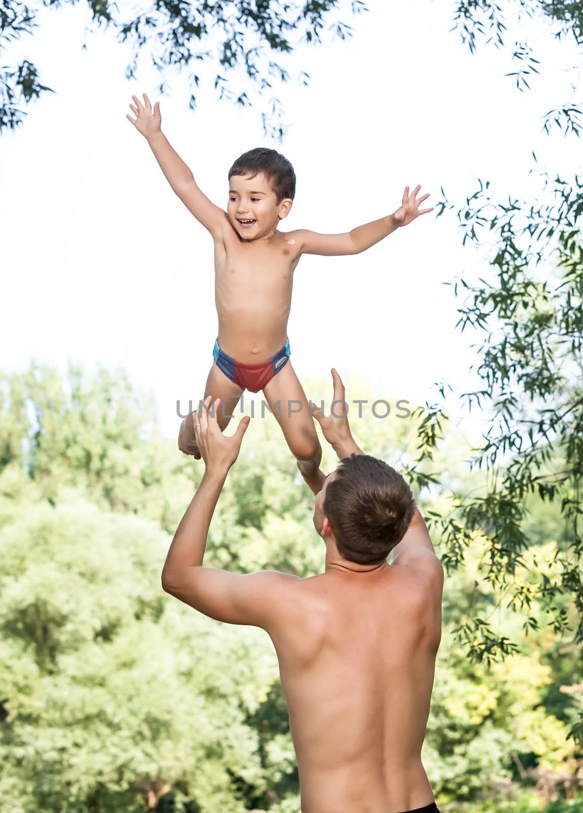 Father throwing his son in the air and catching him