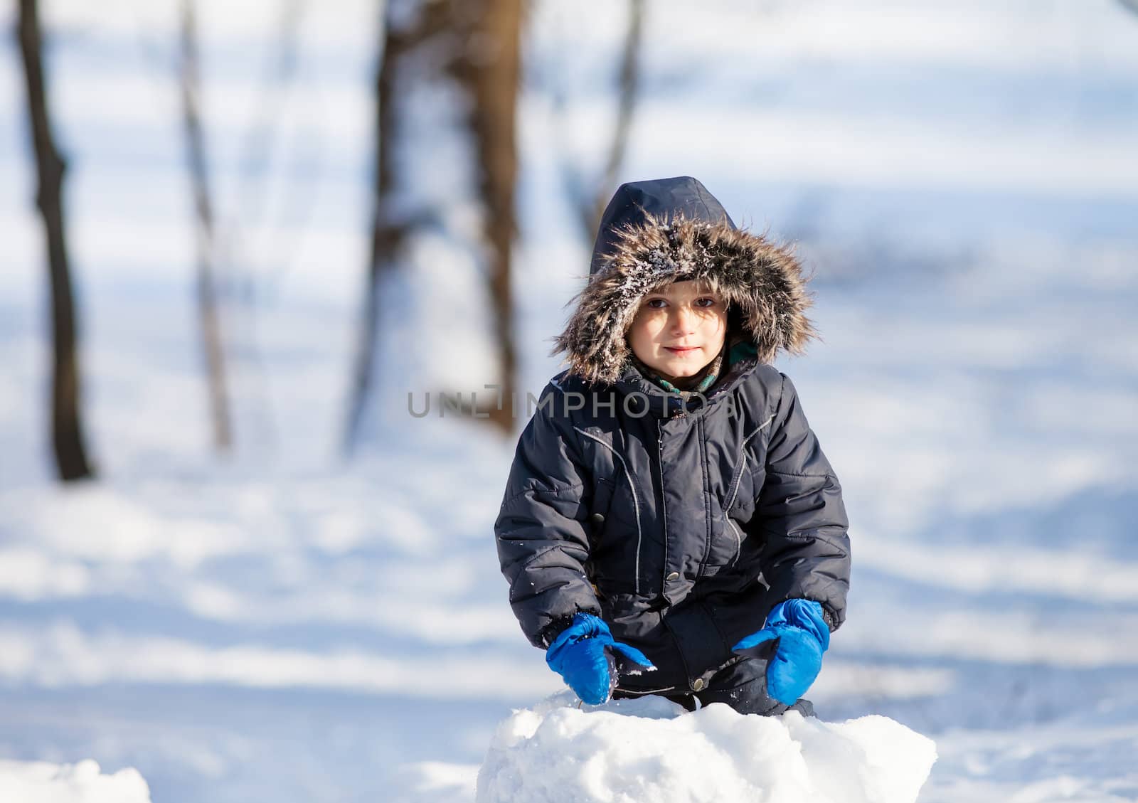 Cute boy playing with snow by palinchak