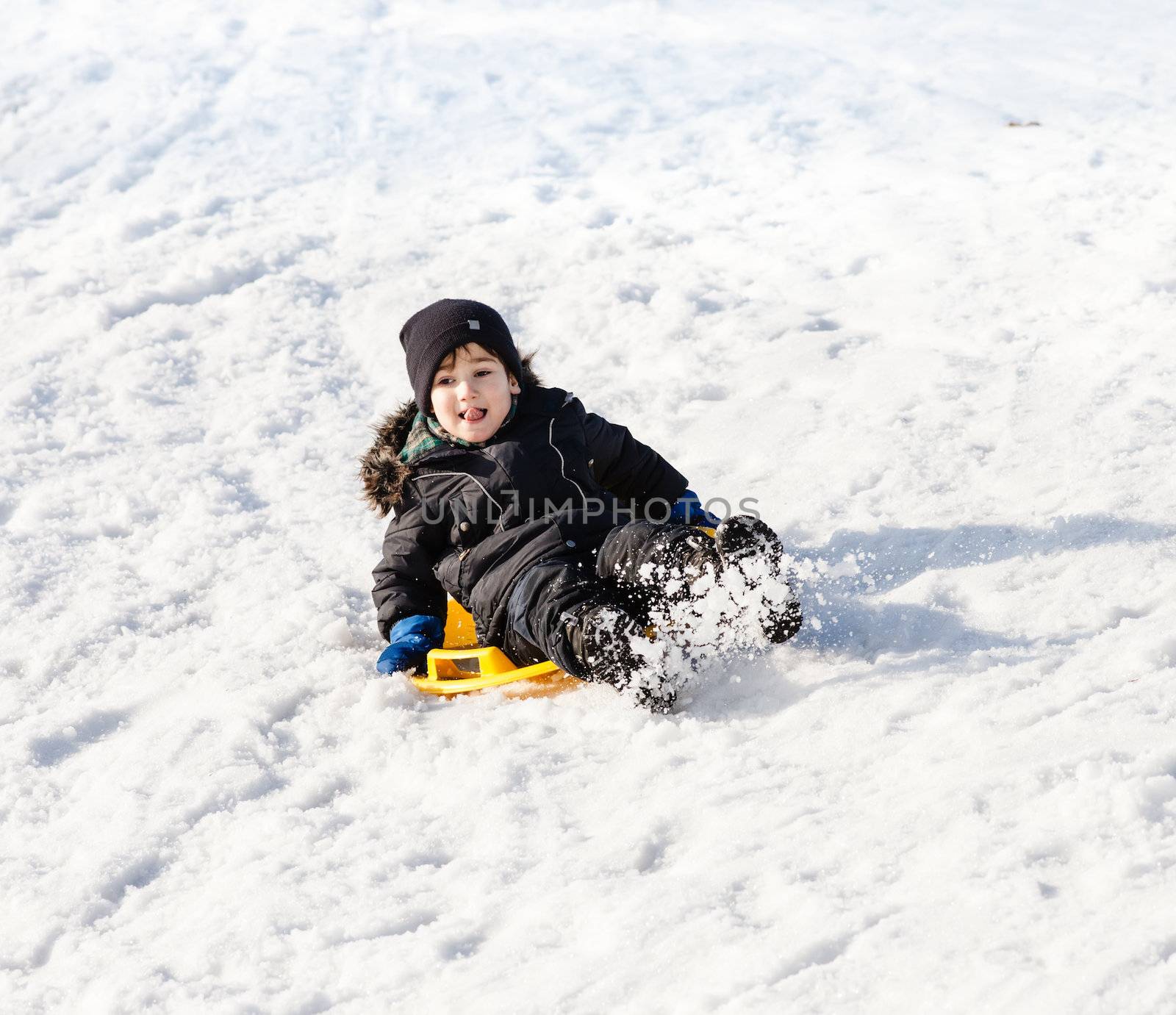 Boy on sleigh. Sledding at winter time