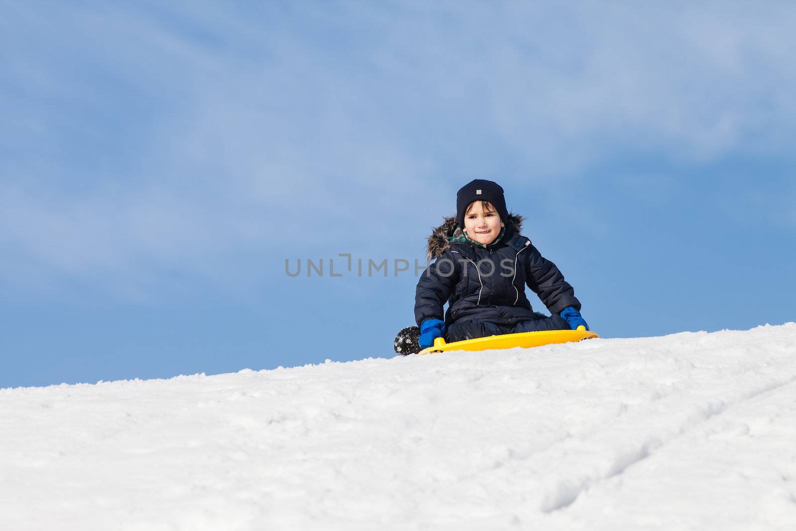 Boy on sleigh. Sledding at winter time