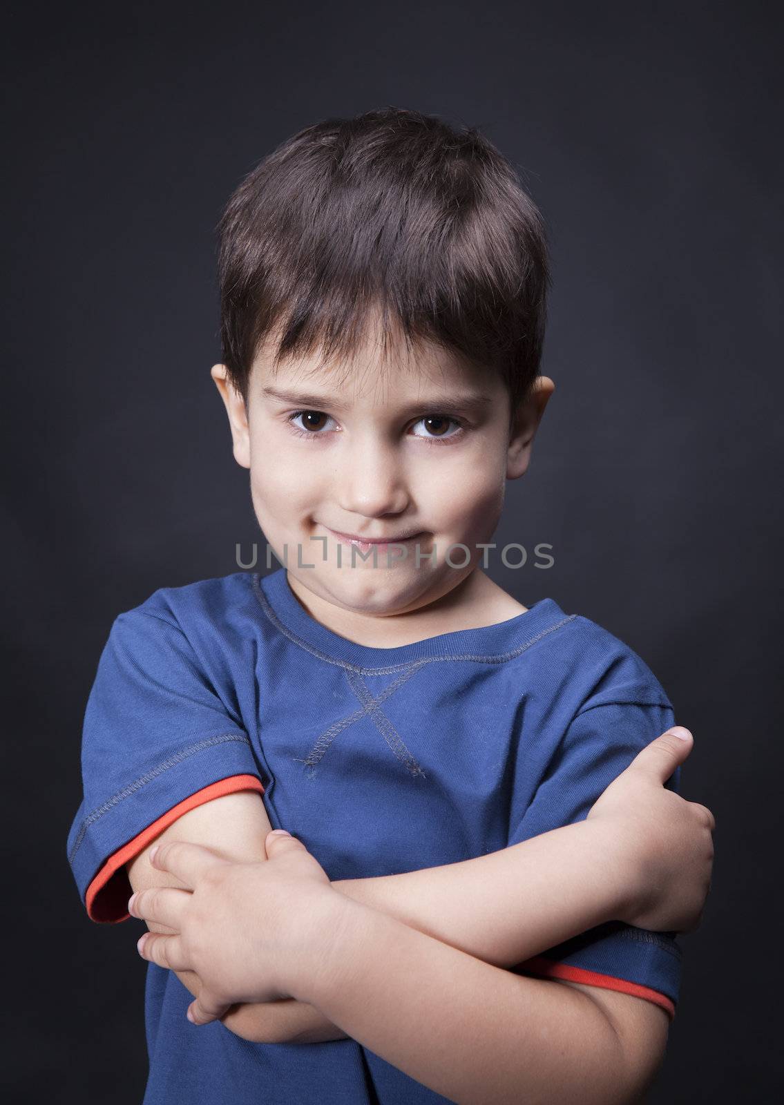 Portrait of a boy with a skeptical look on his face and crossed arms