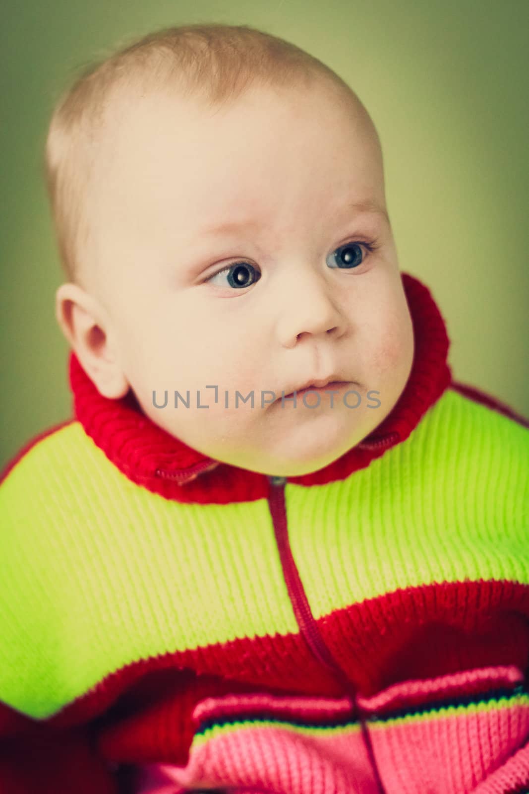 Portrait Of Sad Baby Boy On Green Background by ryhor