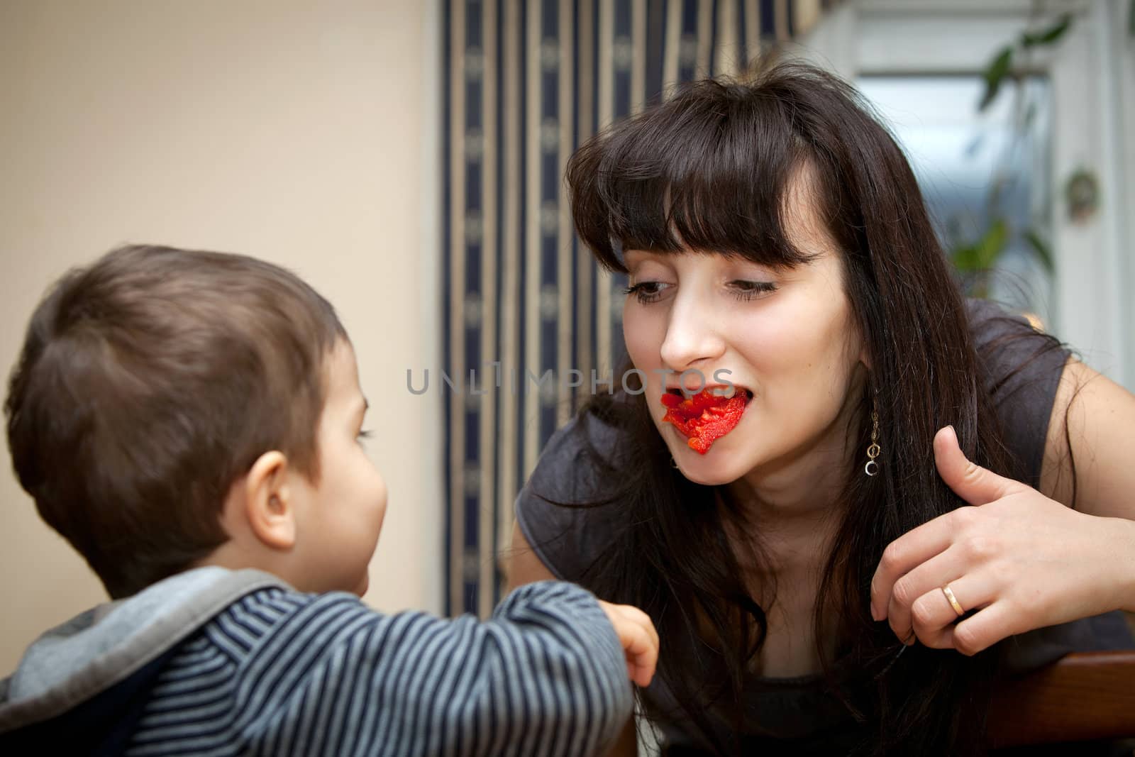  boy gives a piece of red pepper to mother by palinchak
