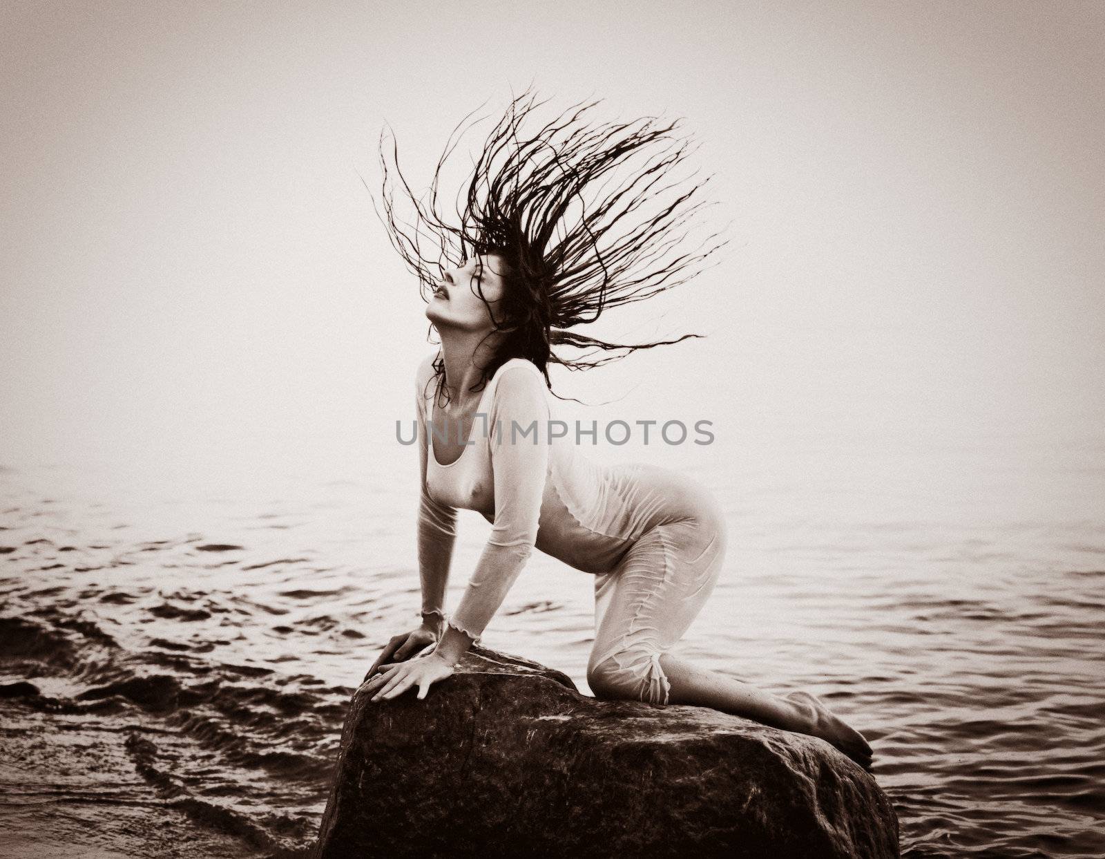 Breeze. Woman with hair flying in the wind. Old photo stylization, film grain added