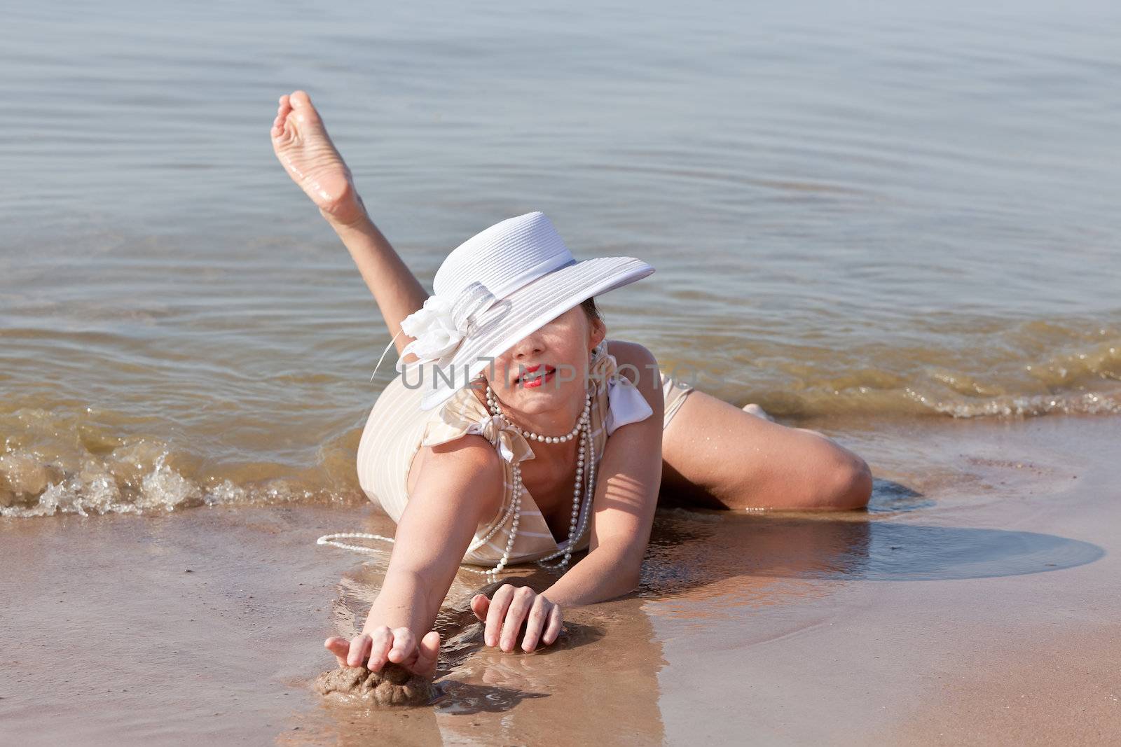 Woman in white hat posing against the sea by palinchak