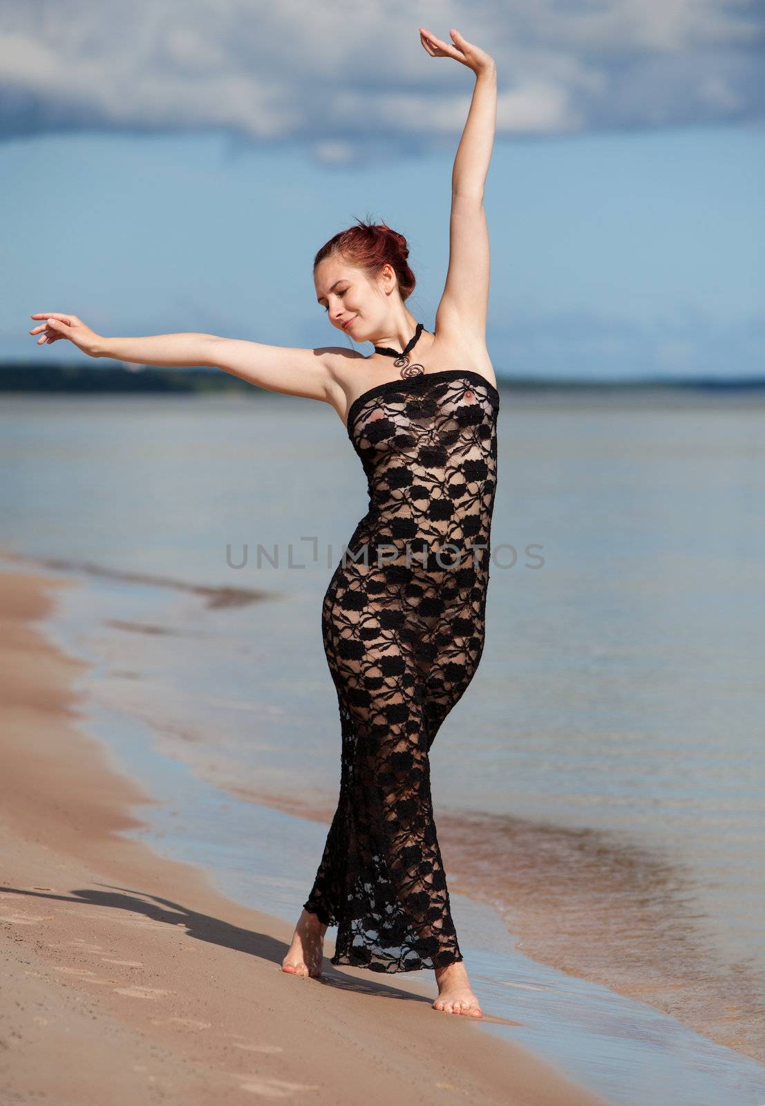 woman in black lace dress against the sea