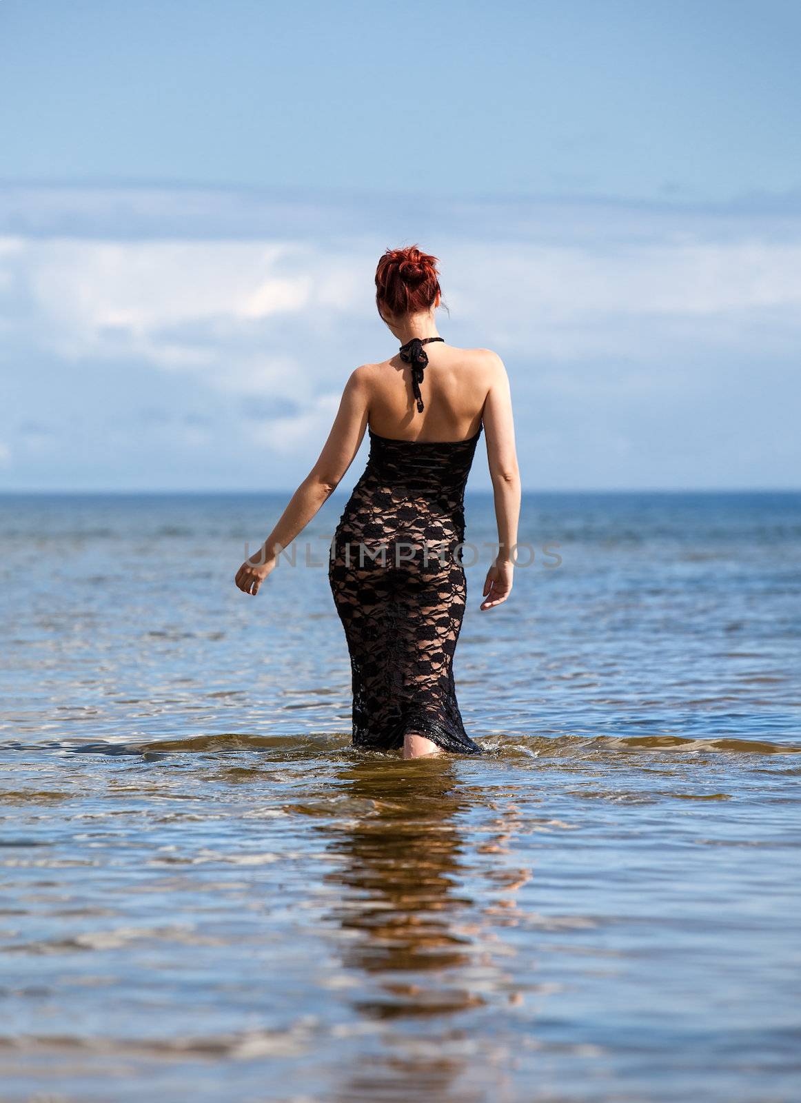 woman in black lace dress against the sea