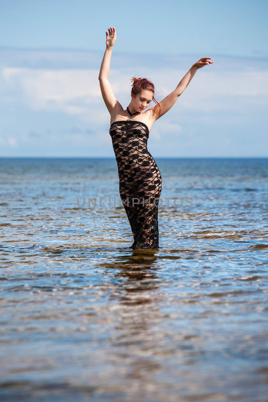 woman in black lace dress against the sea
