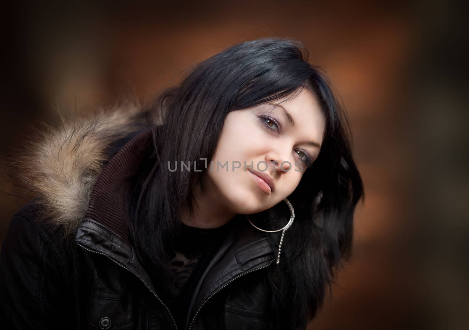 Young woman in a leather jacket on blurred background