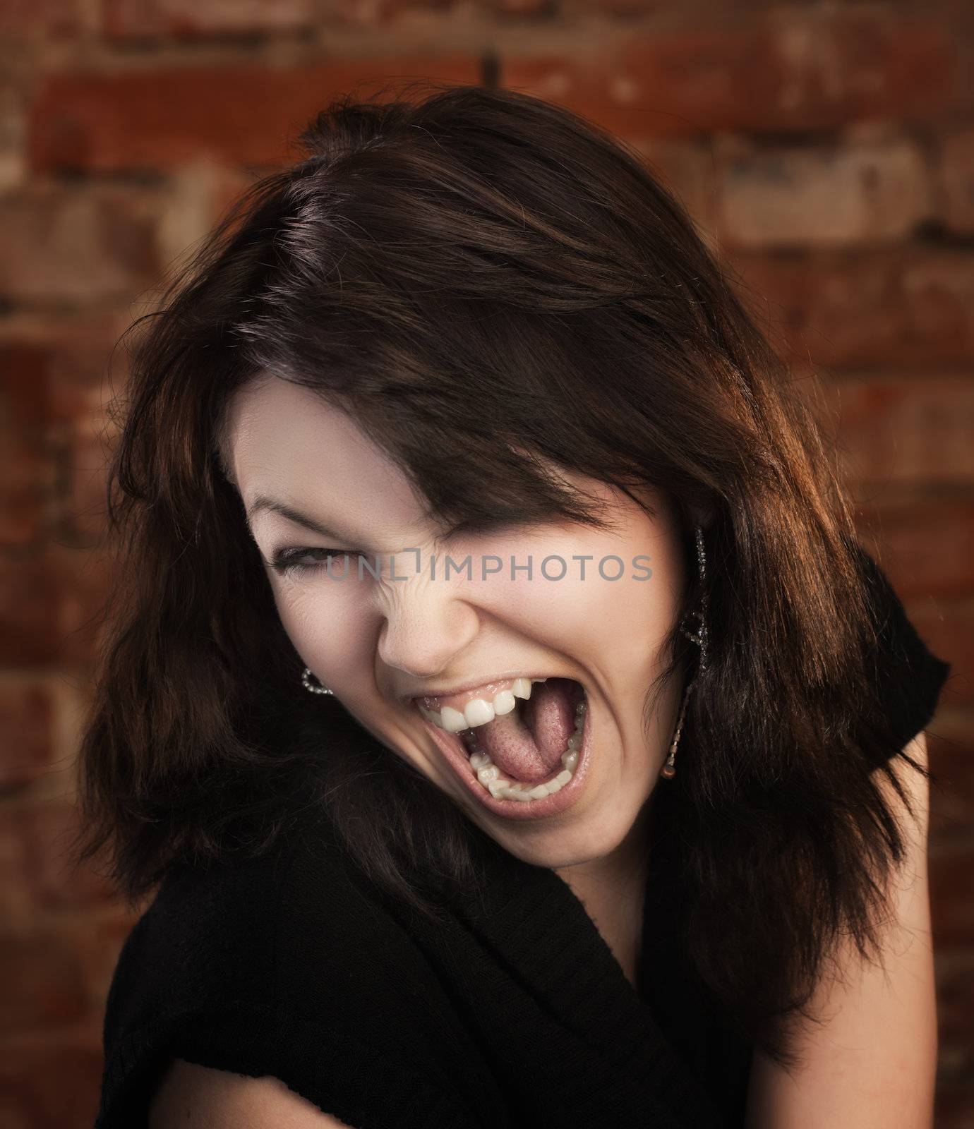 Joyful young girl on brick wall background