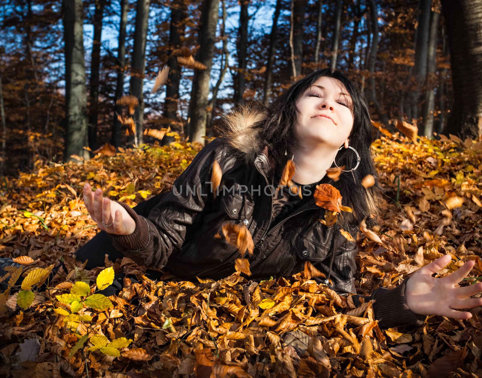 Young woman lying in fallen leaves by palinchak