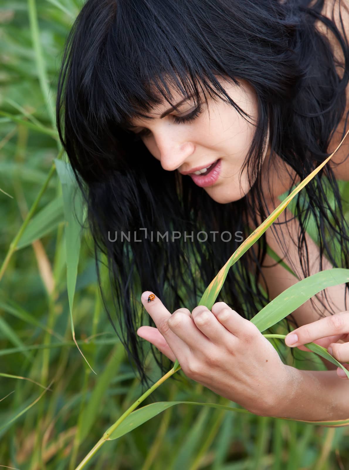 Young woman and ladybird on her finger. Focus mainly on hand