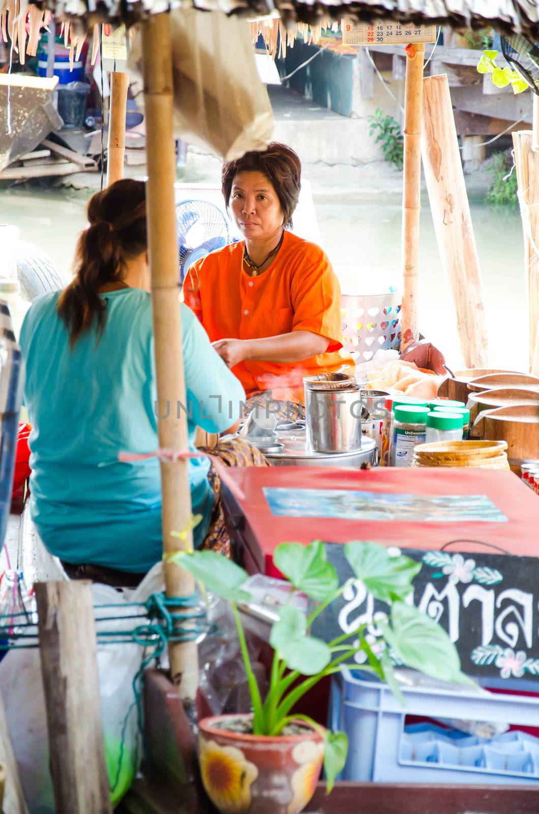 AYUTTHAYA - SEPTEMBER 22:  Tourists and people sell food items at Ayothaya Floating Market on September 22, 2013 in Ayutthaya, Thailand. Ayothaya Floating Market  is a very popular tourist attraction.