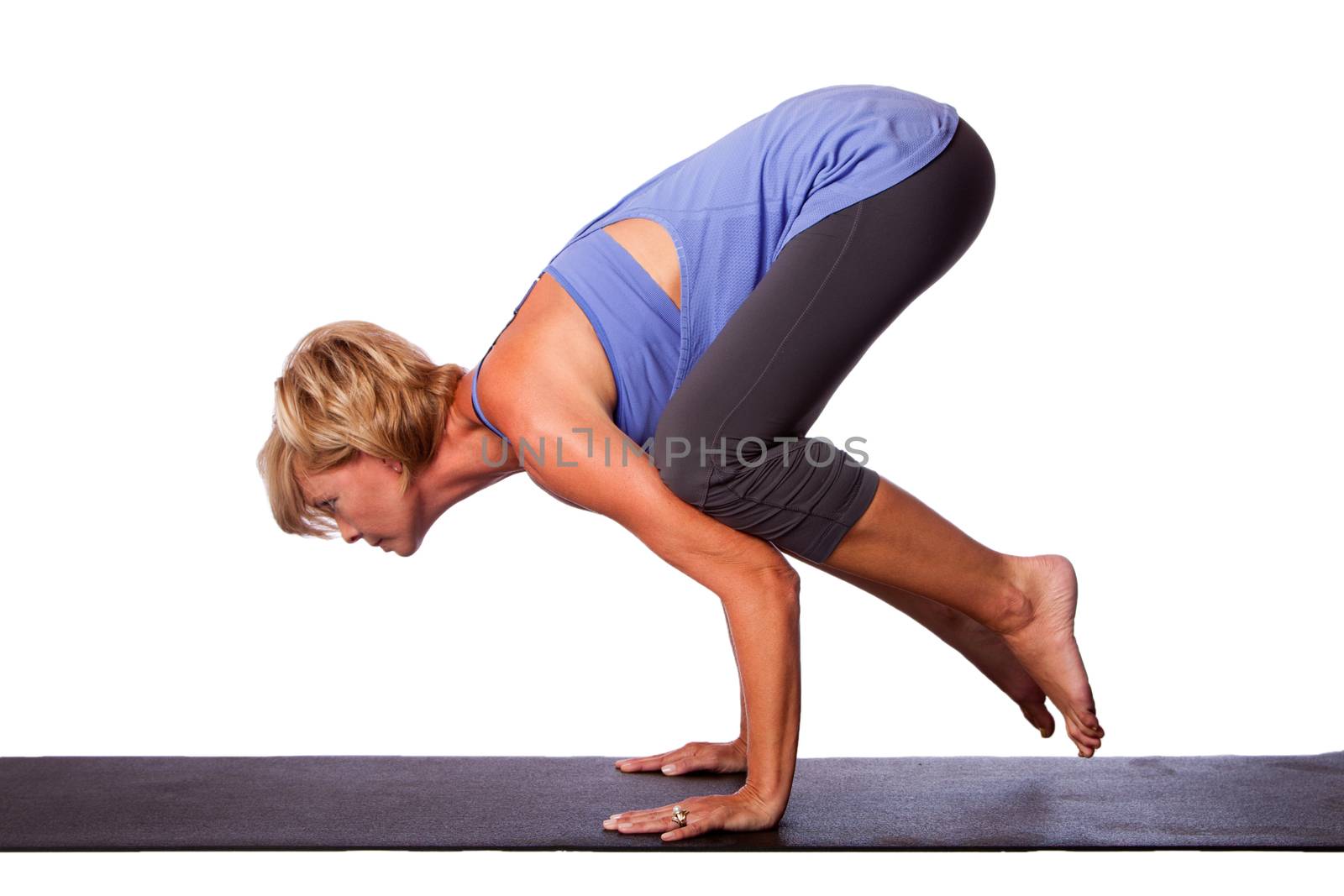Beautiful woman standing on hands with feet lifted up doing Crane Bakasana yoga pose, on white.