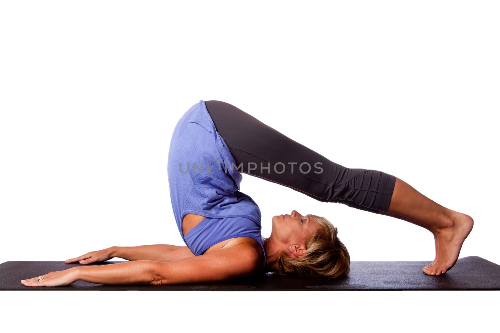 Back stretch Plow Halasana yoga pose by beautiful healthy woman with legs over her head, on white.